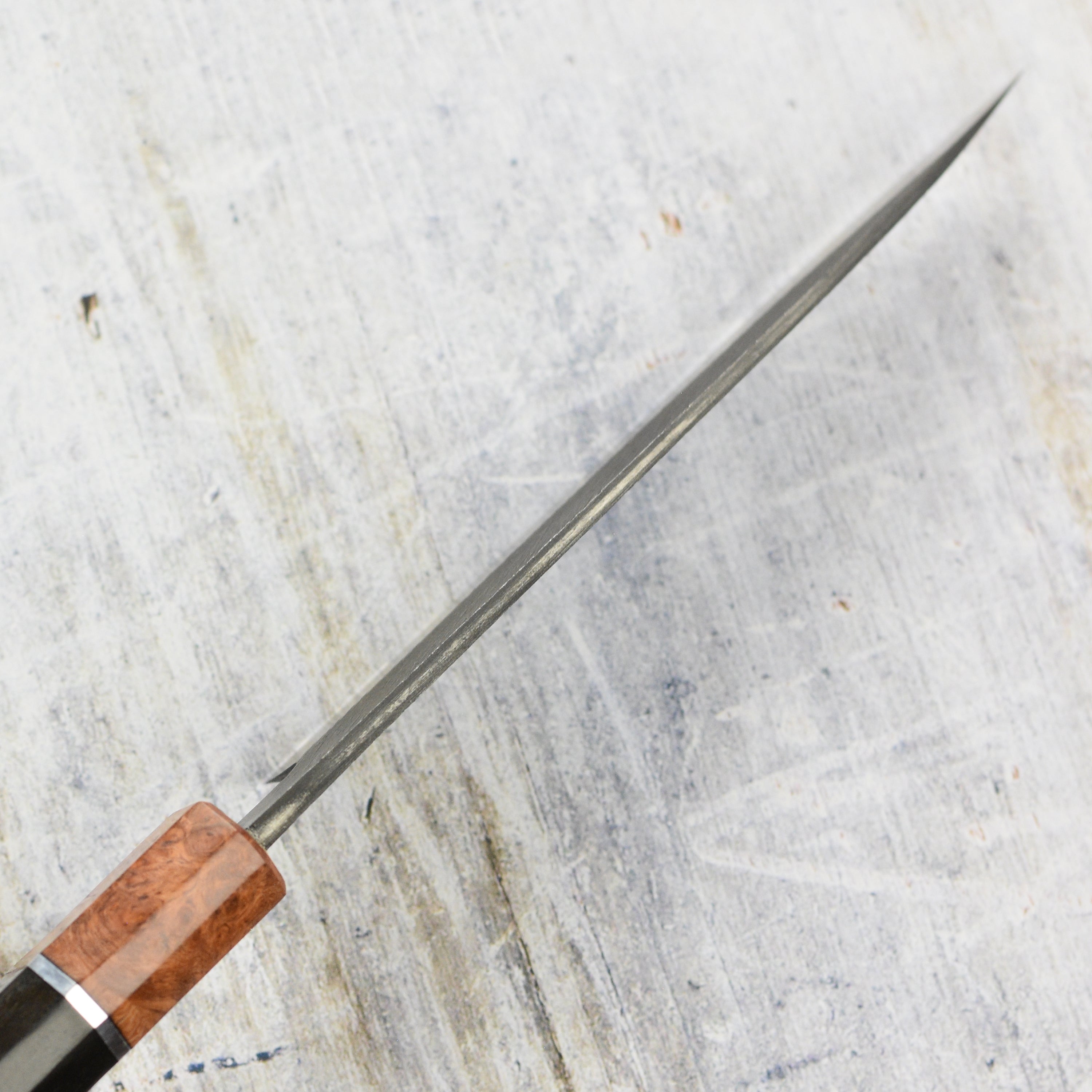 Chef using a high-quality Japanese kitchen knife for precise slicing