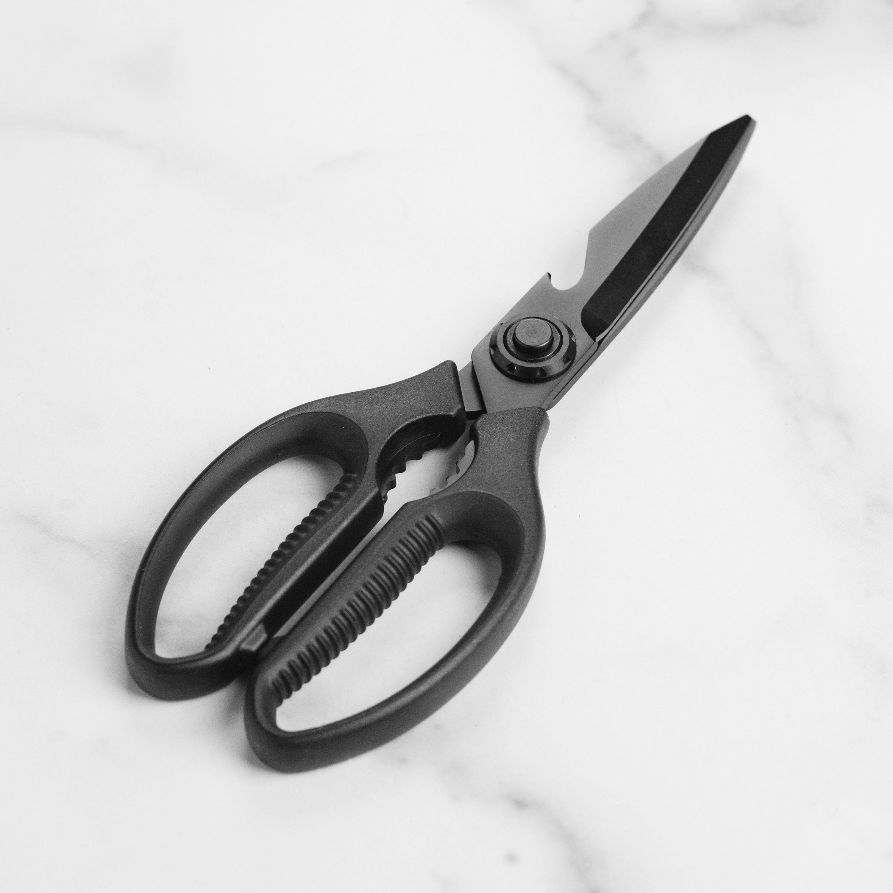 TitanEdge multi-functional shears slicing through poultry on a wooden board