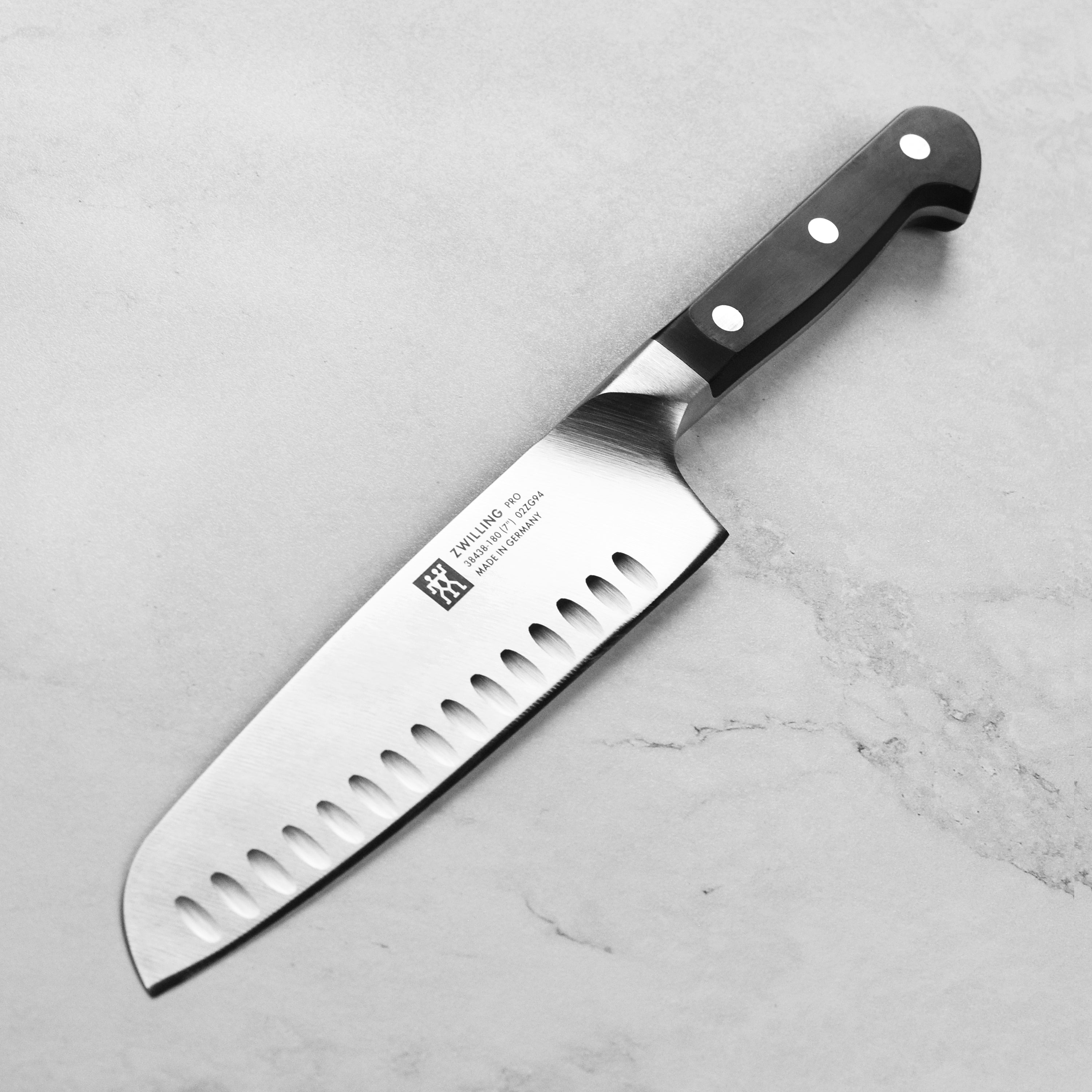 Zwilling Pro 7-inch hollow edge Santoku knife with sharp blade and ergonomic handle for precision slicing