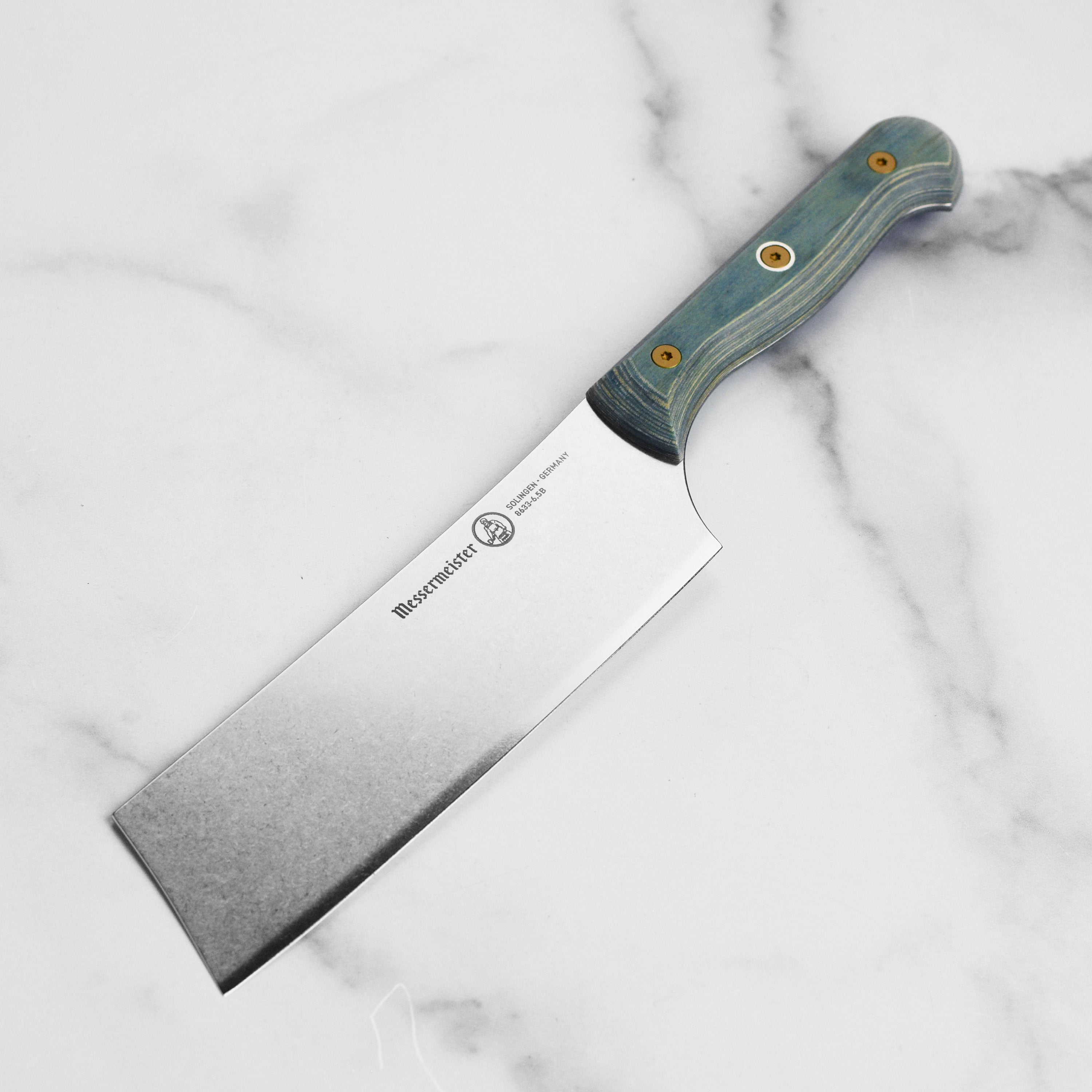 Messermeister Nakiri knife showing the blade's ceramic stonewash finish and ergonomic handle.