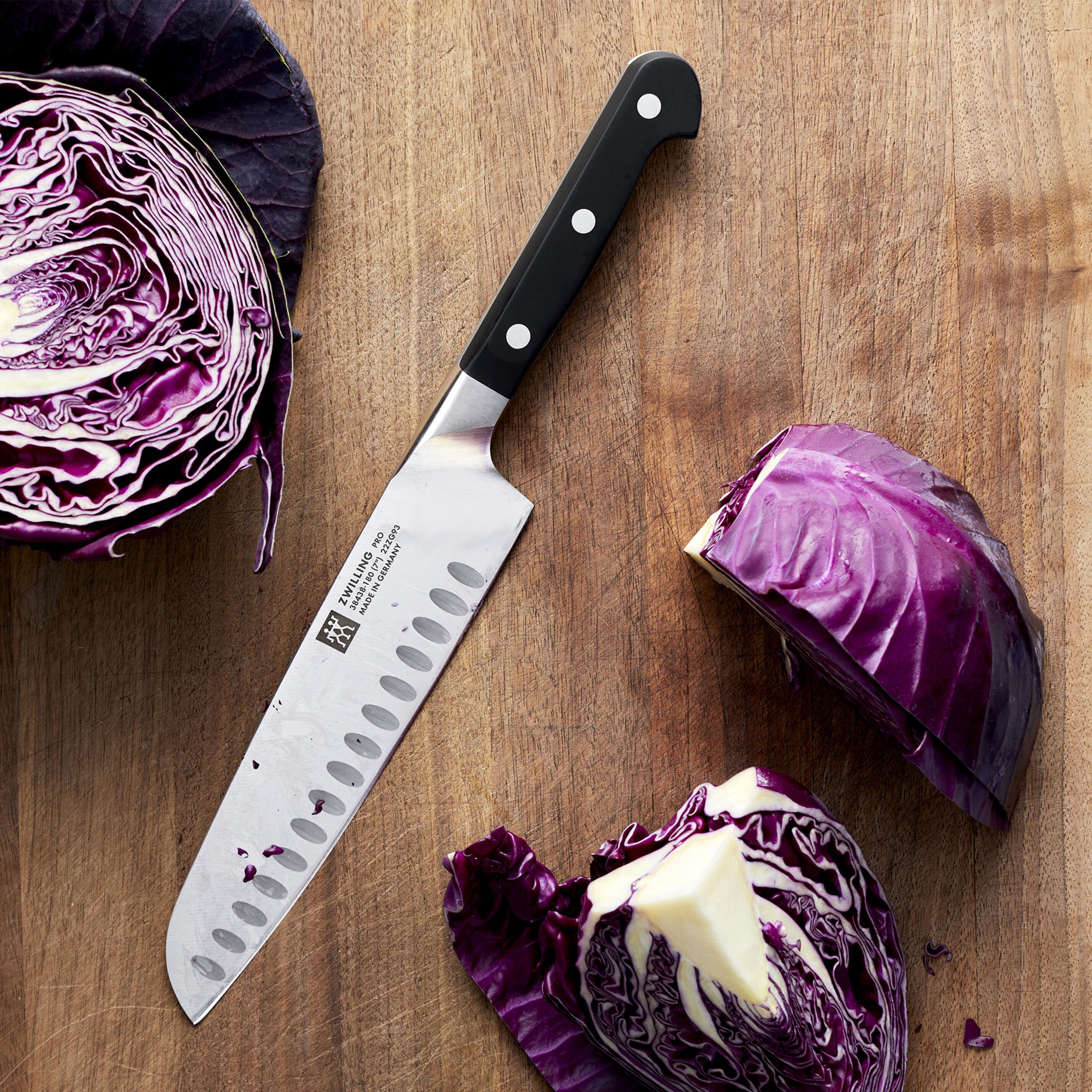 Professional chef using Zwilling Pro Santoku knife on vegetables in a modern kitchen