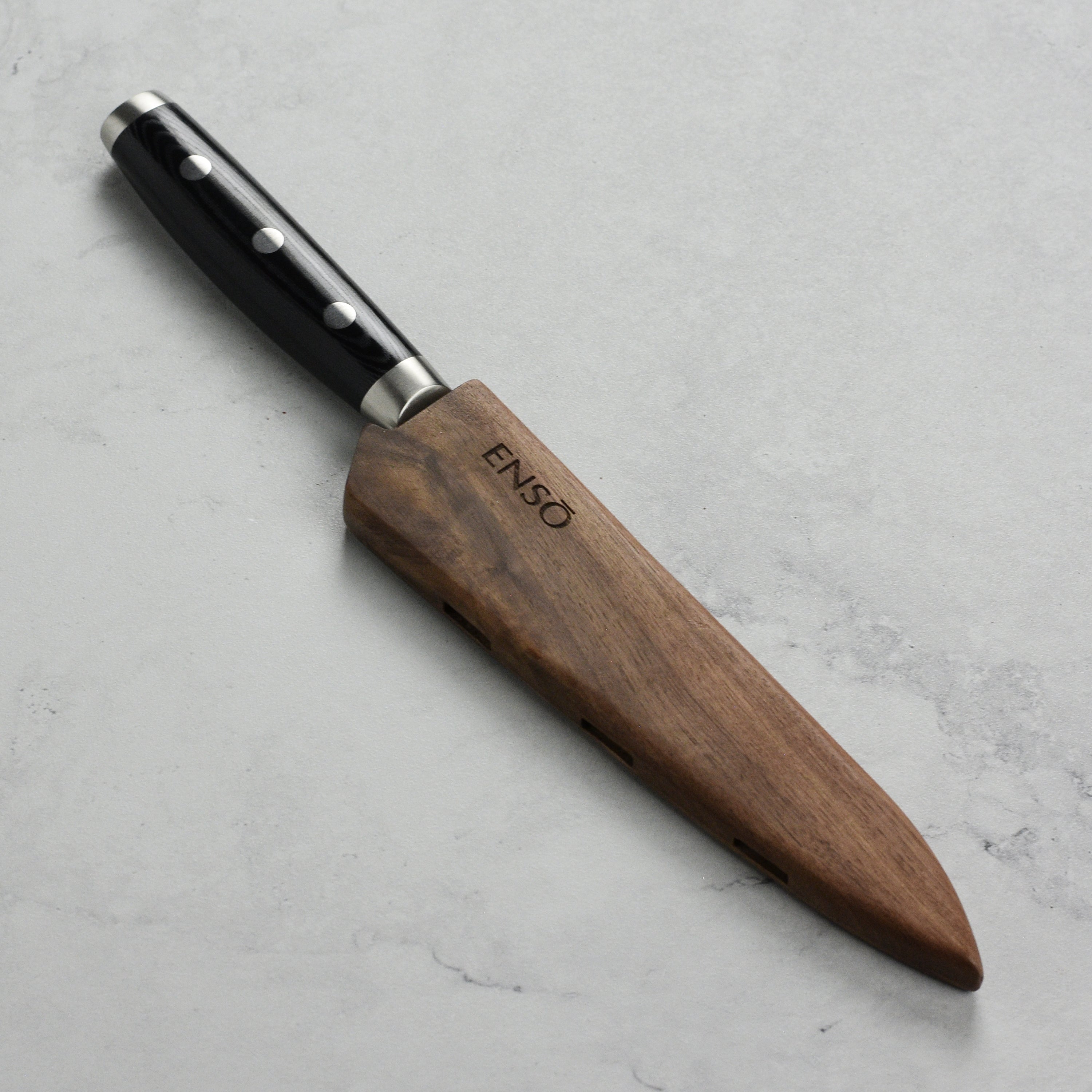Close-up of the Enso Walnut Knife Holder demonstrating its secure fit for a 6-inch utility knife.