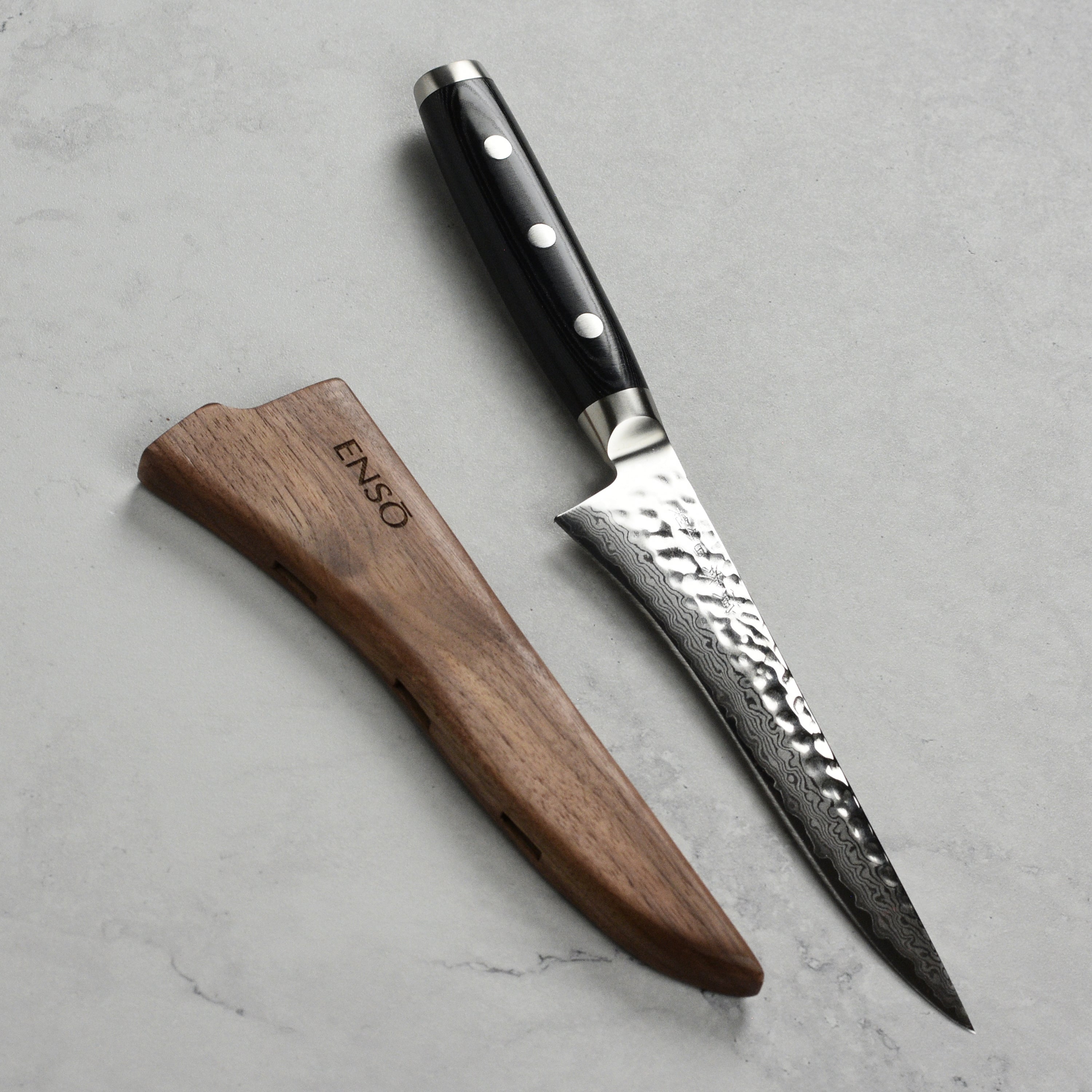 Close-up of walnut magnetic sheath holding a 6-inch knife securely