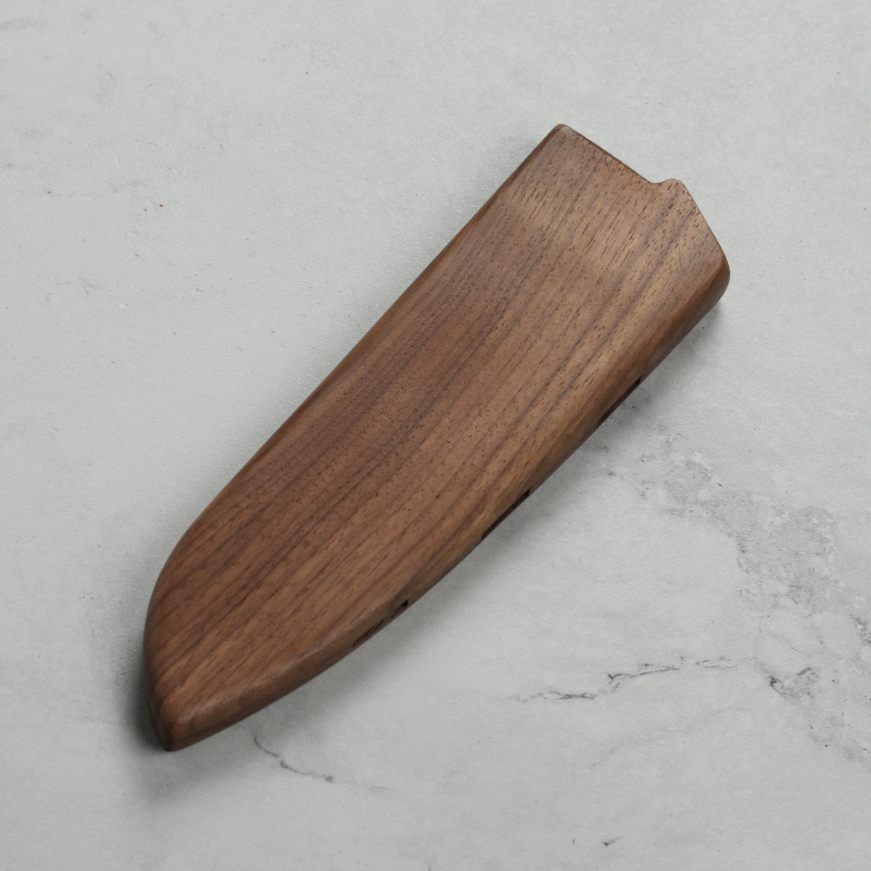 Knife sheath placed on countertop beside Santoku knife for daily use