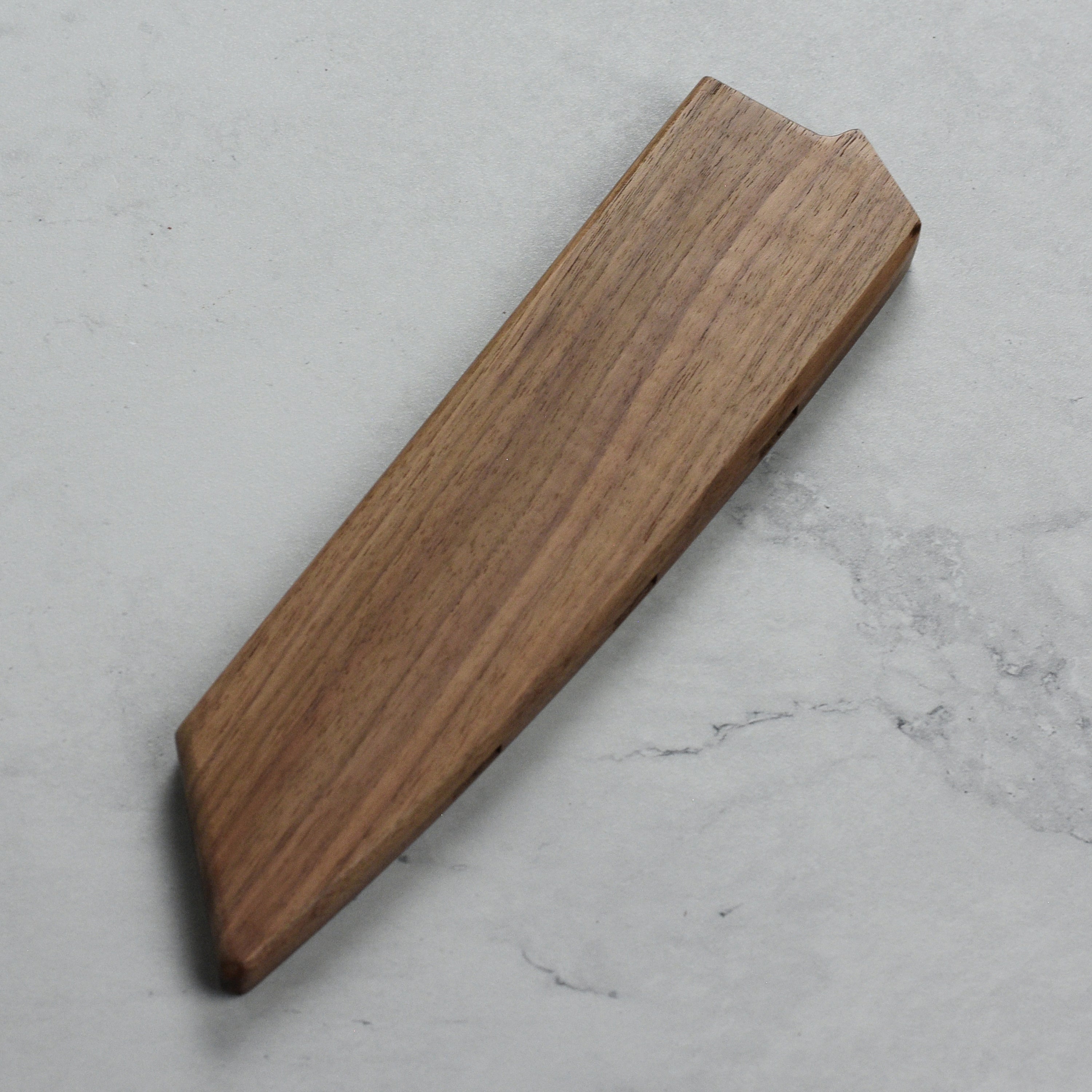 Magnetic knife cover in use, securely holding an 8" Kiritsuke knife on a kitchen wall.