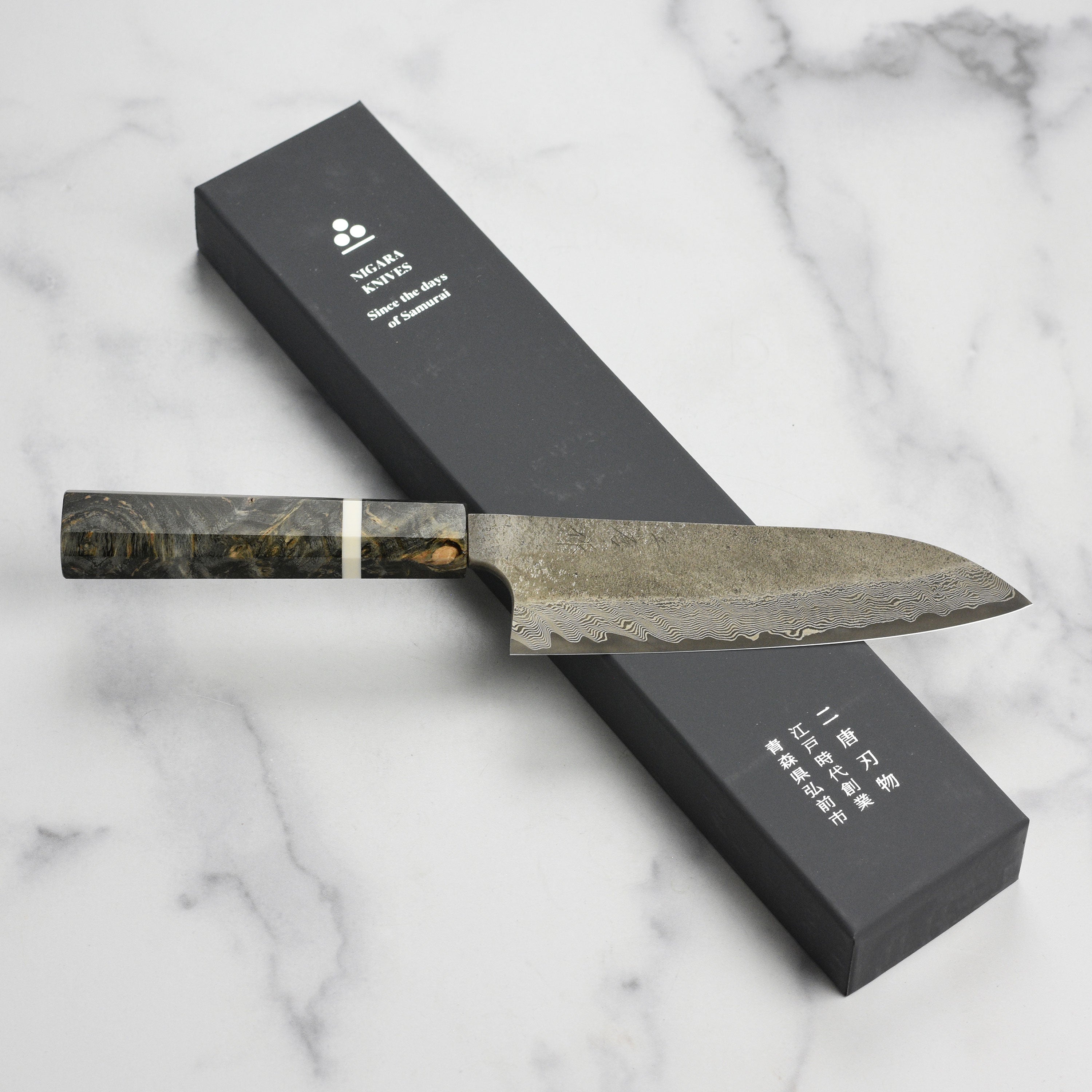 Close-up of Nigara Ginsan Kurozome Damascus Santoku knife showing damascus pattern