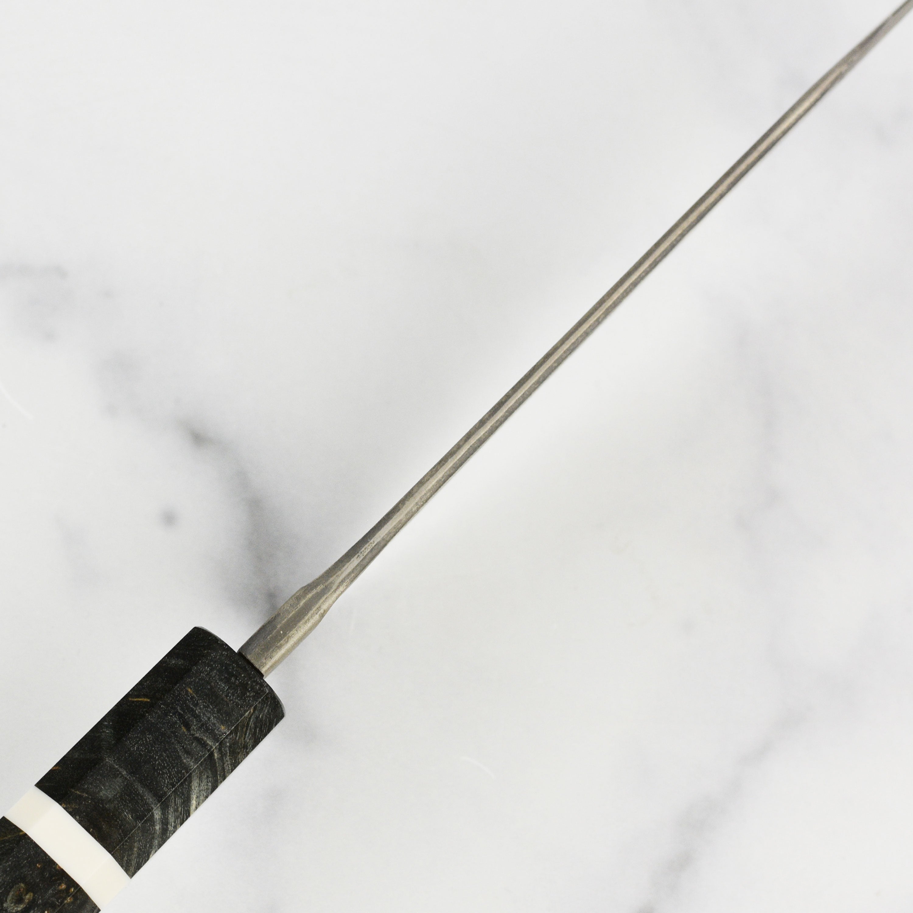 Nigara Ginsan Kurozome Damascus bunka knife angled for precision slicing
