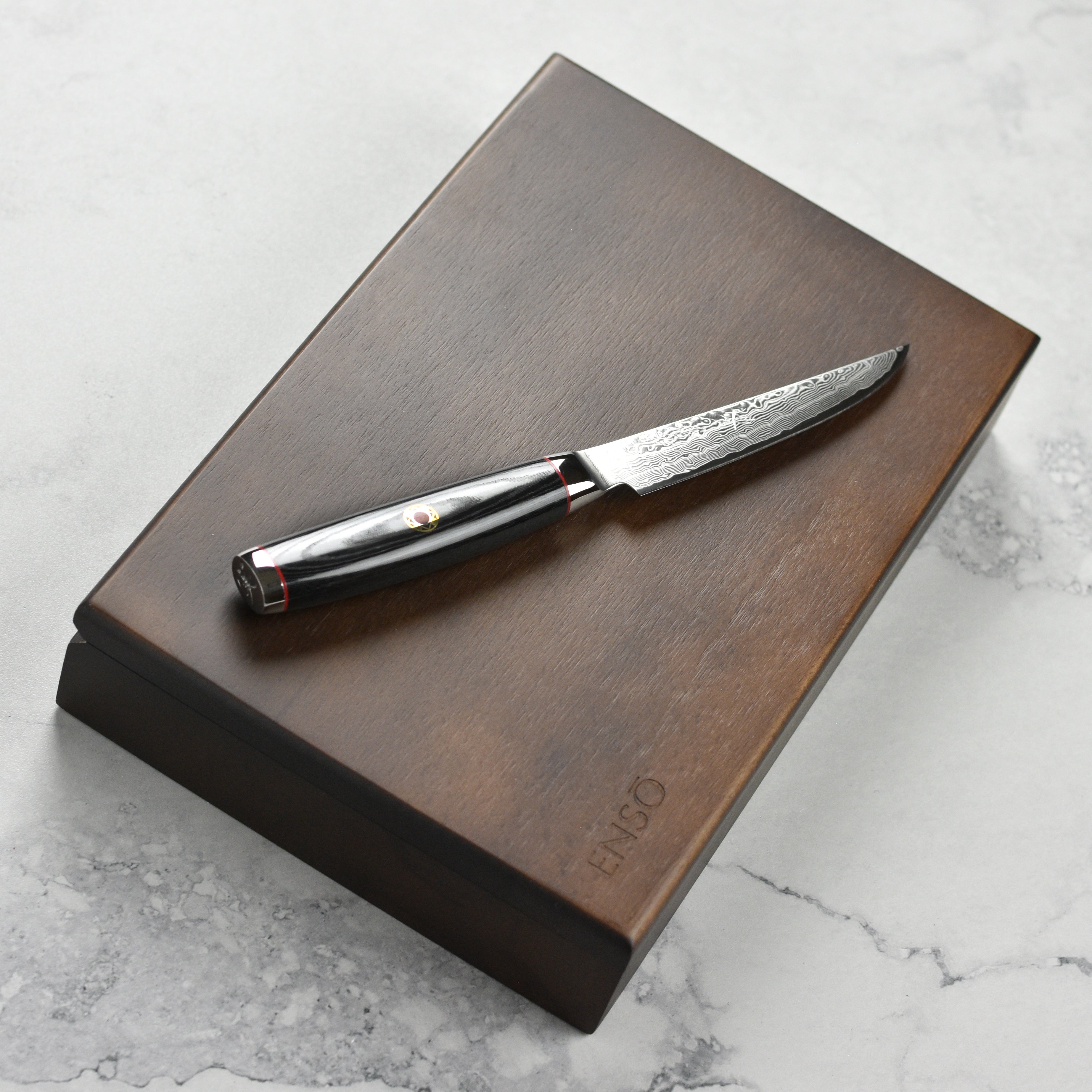Side angle of Japanese Damascus steak knife highlighting 101-layer detail