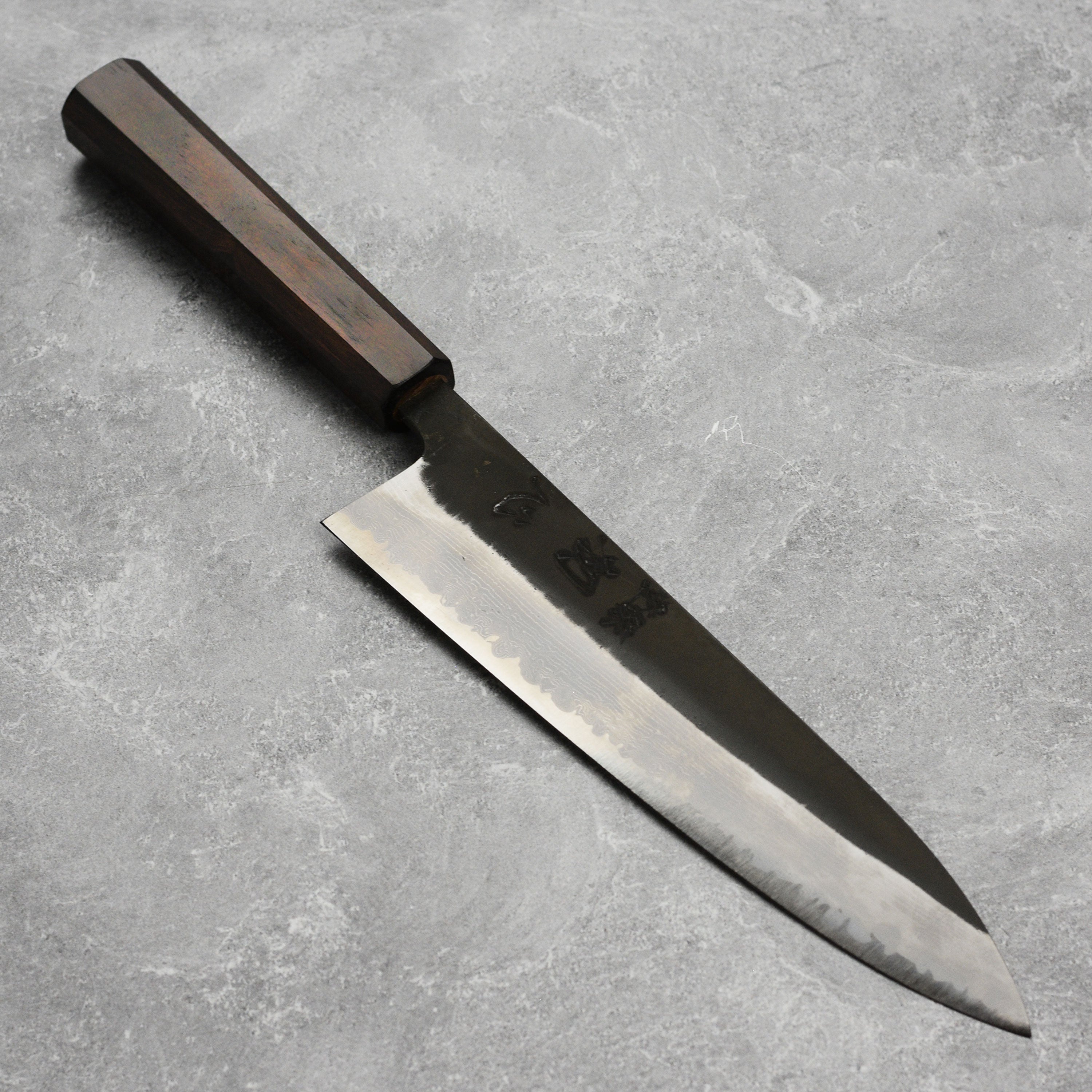 Damascus Gyuto chef knife with ebony handle showing intricate steel pattern