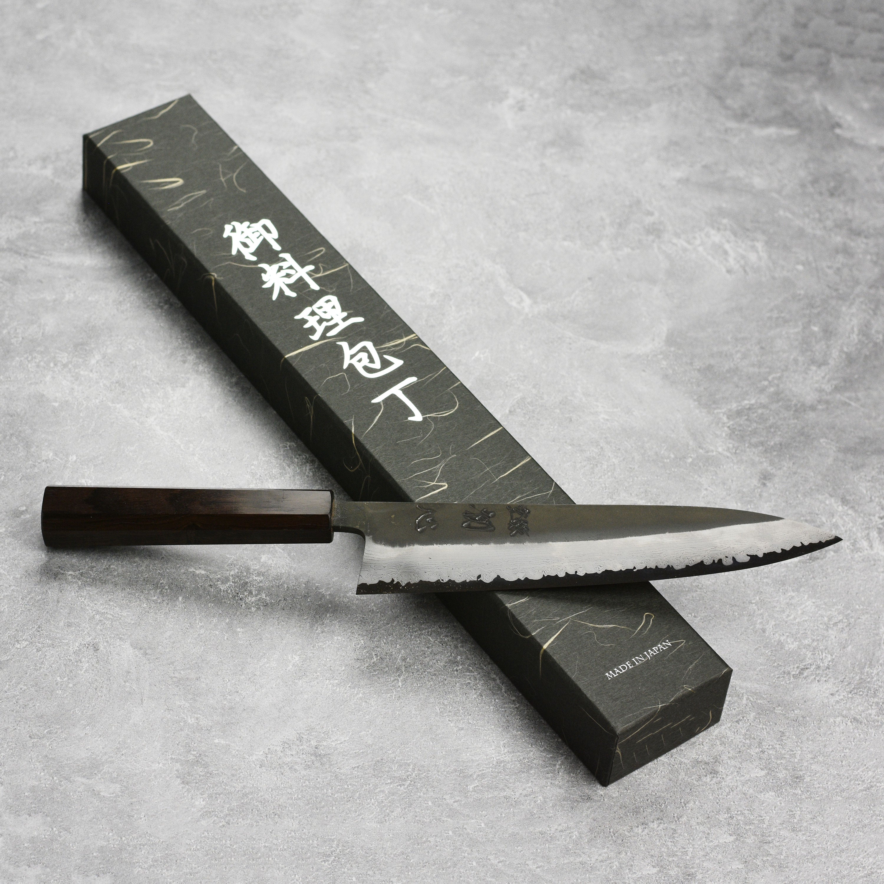 Damascus Gyuto chef knife with ebony handle showing intricate steel pattern