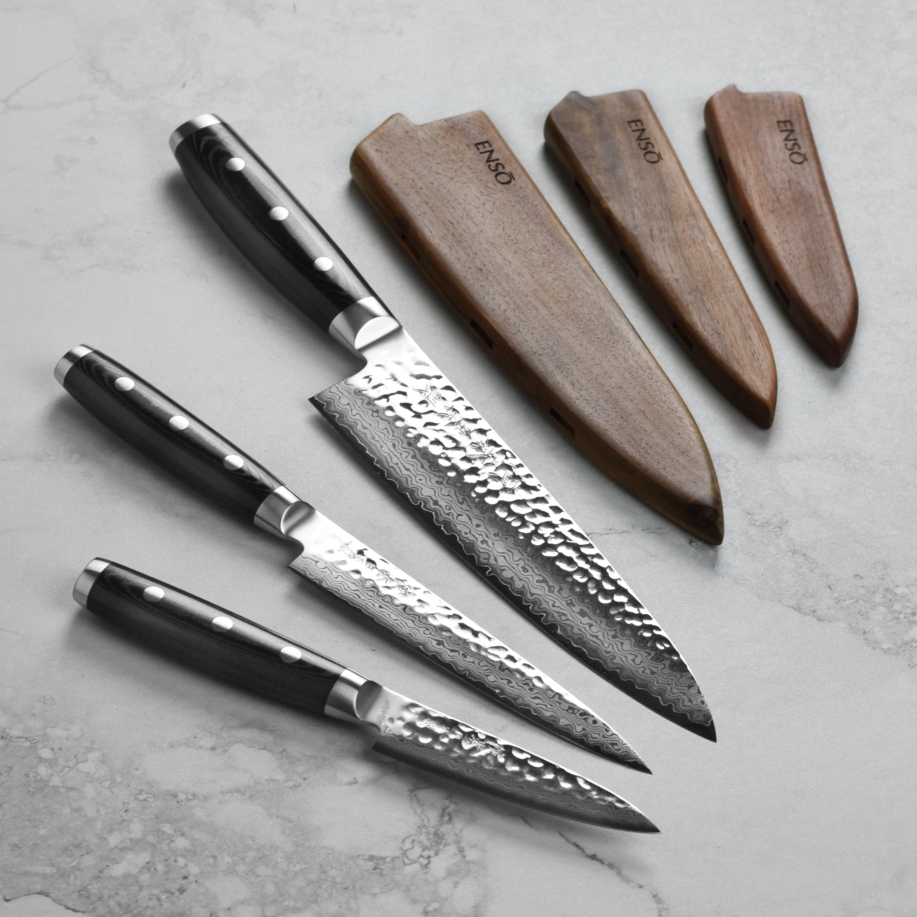 Premium VG-10 Damascus knife set displayed on a wooden cutting board, showcasing the hammered finish