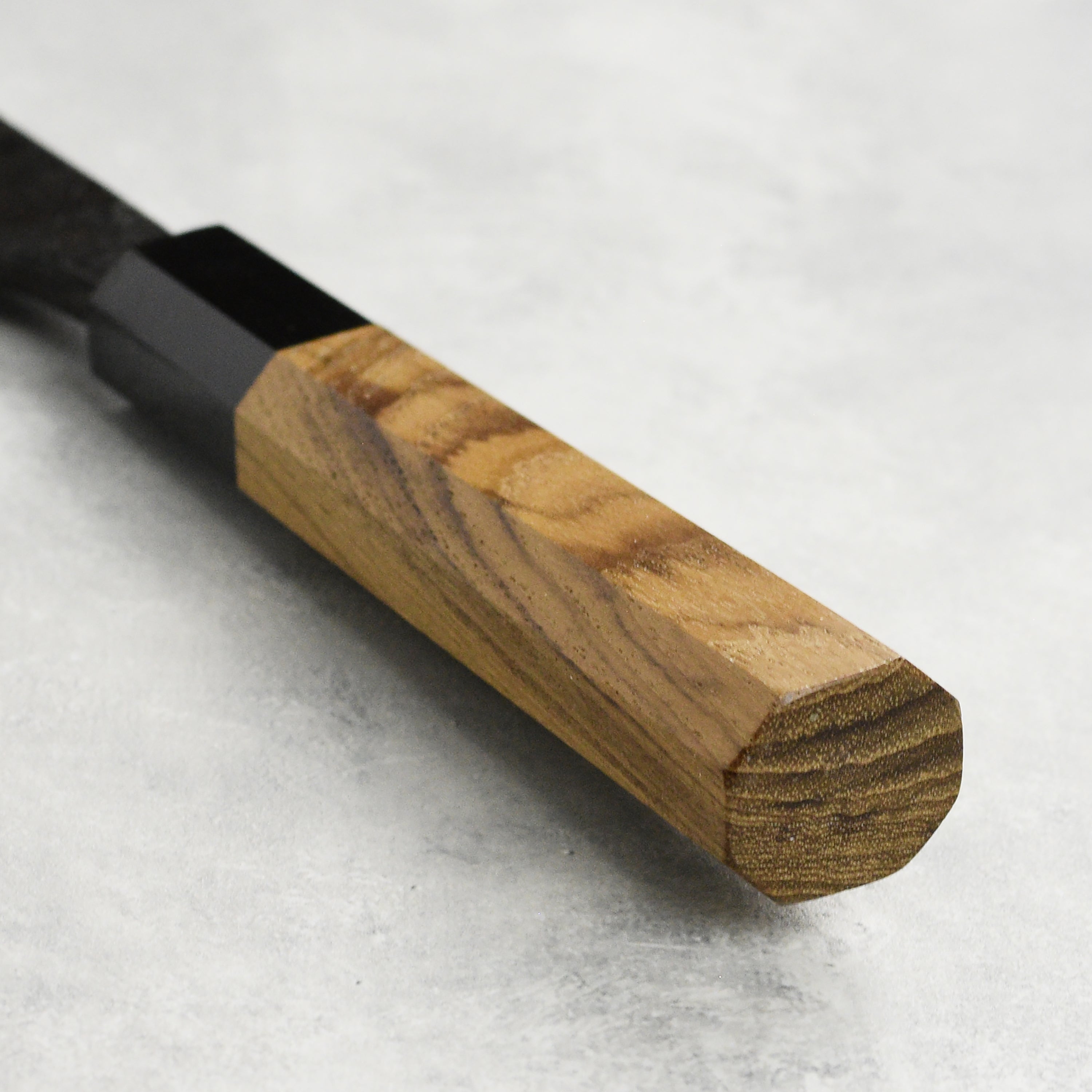 Hatsukokoro Kurokaze Aogami Deba Knife in use, expertly slicing sushi ingredients on a wooden cutting board.