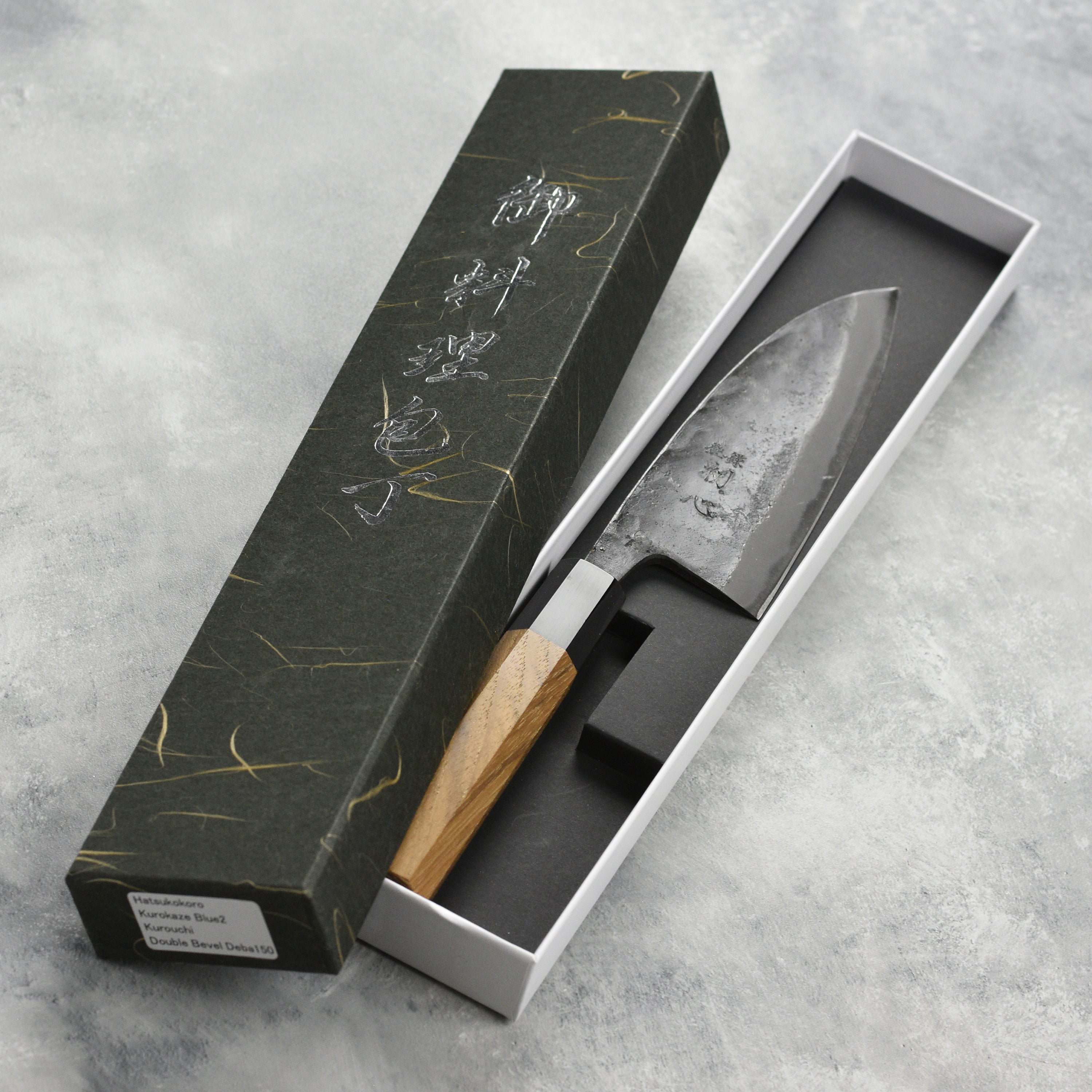 Close-up of the Hatsukokoro Kurokaze Aogami Deba Knife blade, highlighting its sharpness and craftsmanship.