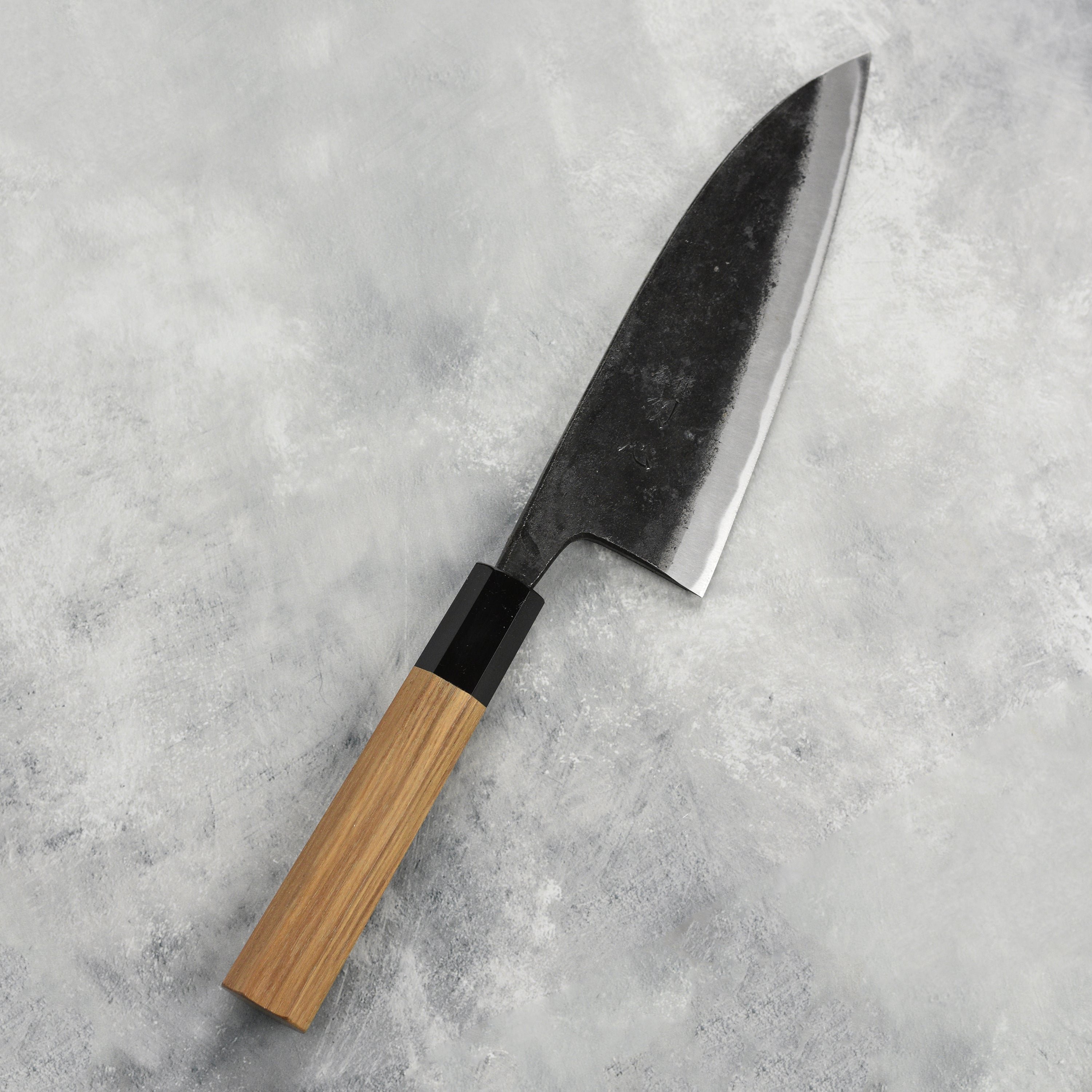 A detailed view of the 6.5-inch double bevel deba knife in a professional kitchen setting