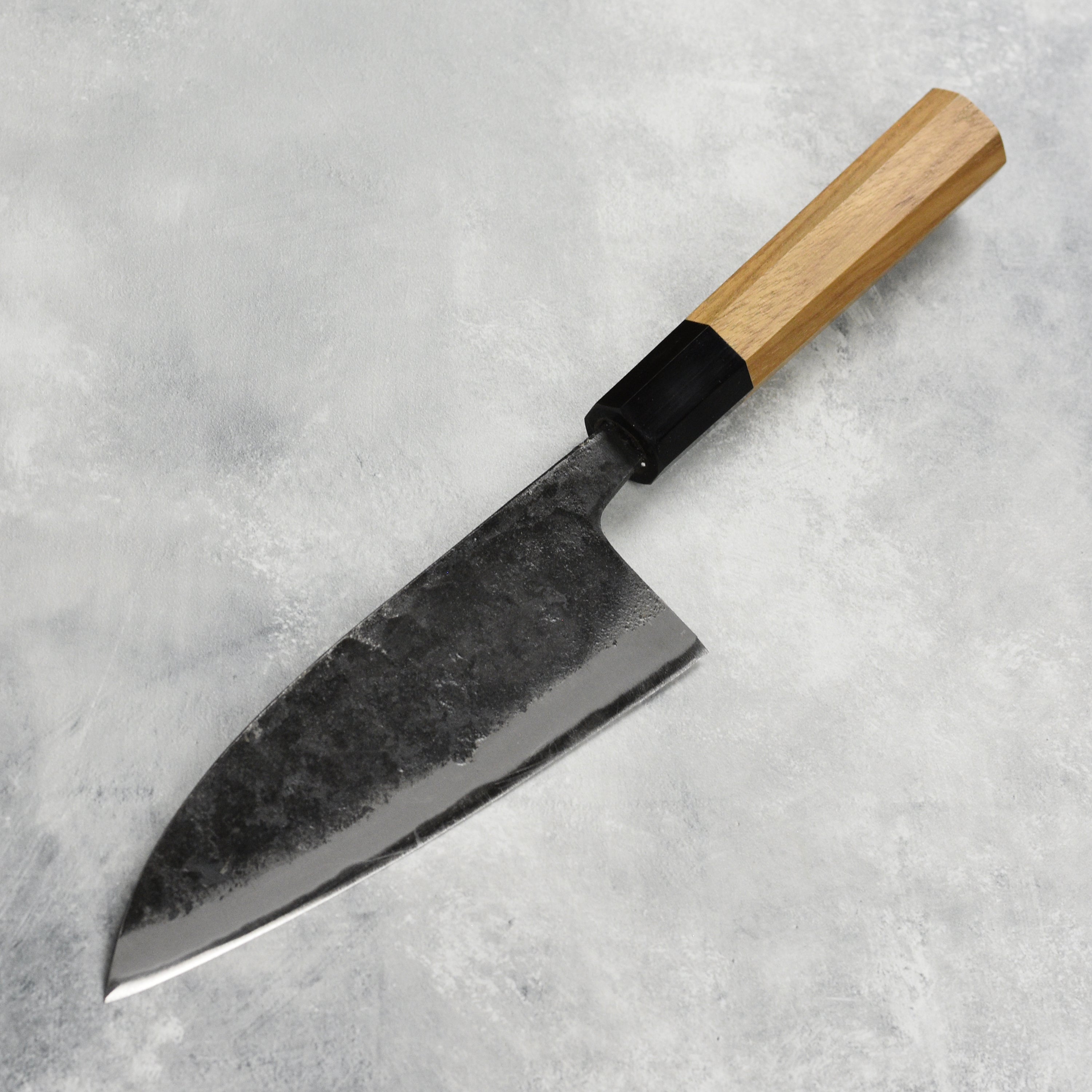 Japanese knife being used to slice fish, showcasing the sharpness and craftsmanship