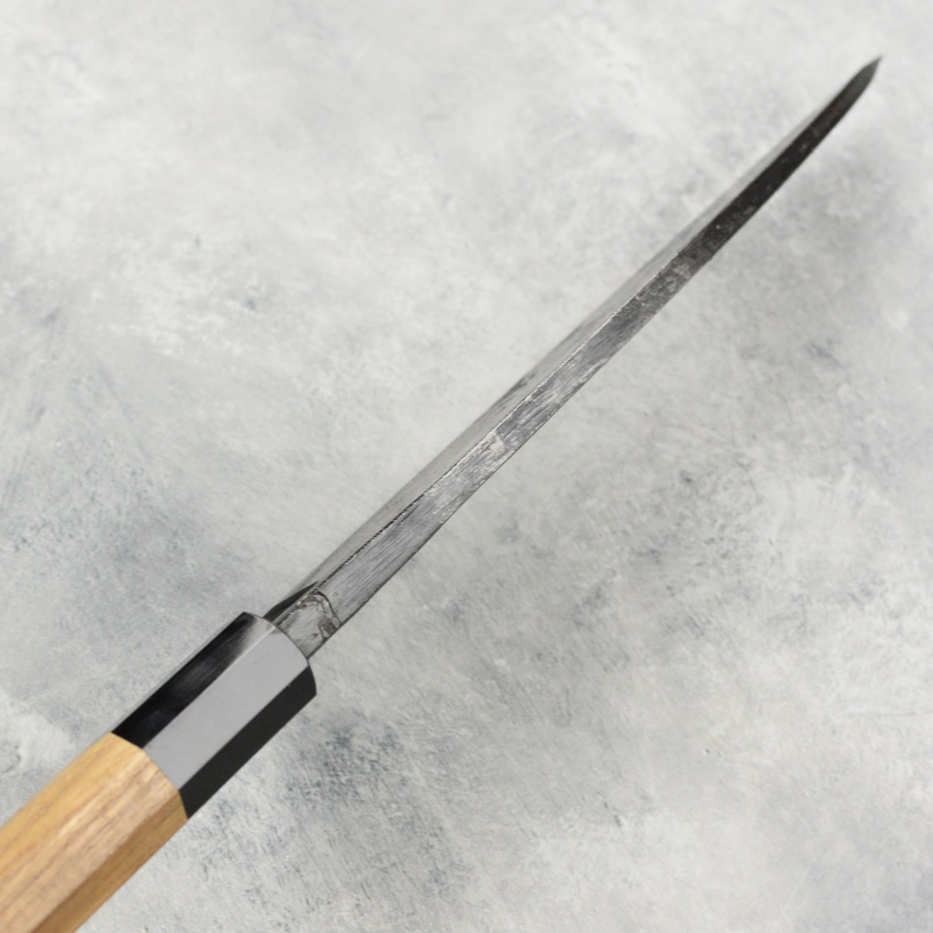 Japanese knife being used to slice fish, showcasing the sharpness and craftsmanship