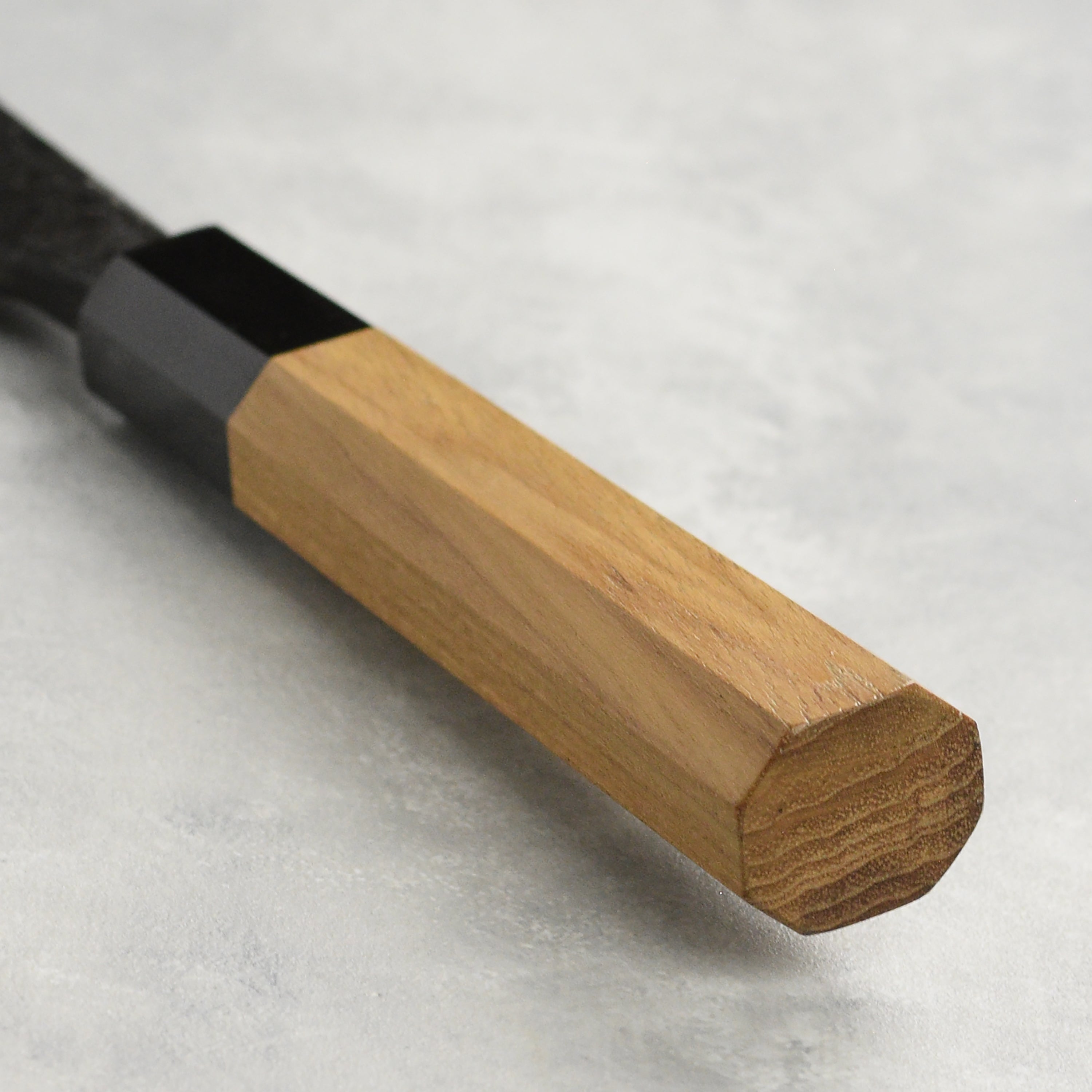 A detailed view of the 6.5-inch double bevel deba knife in a professional kitchen setting
