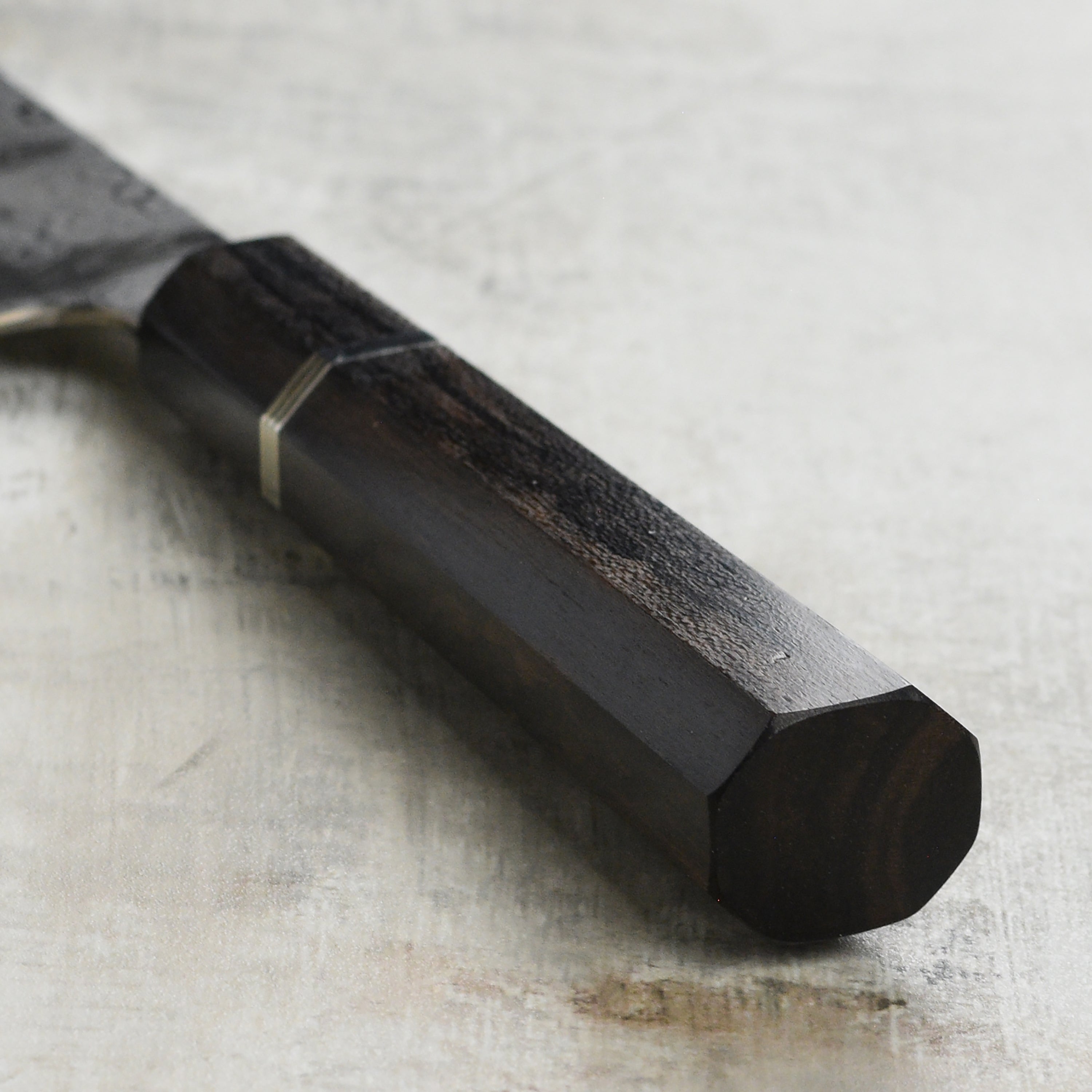 Close-up of the Shiomachi Aogami Gyuto knife cutting fresh vegetables, highlighting its sharp edge and craftsmanship.