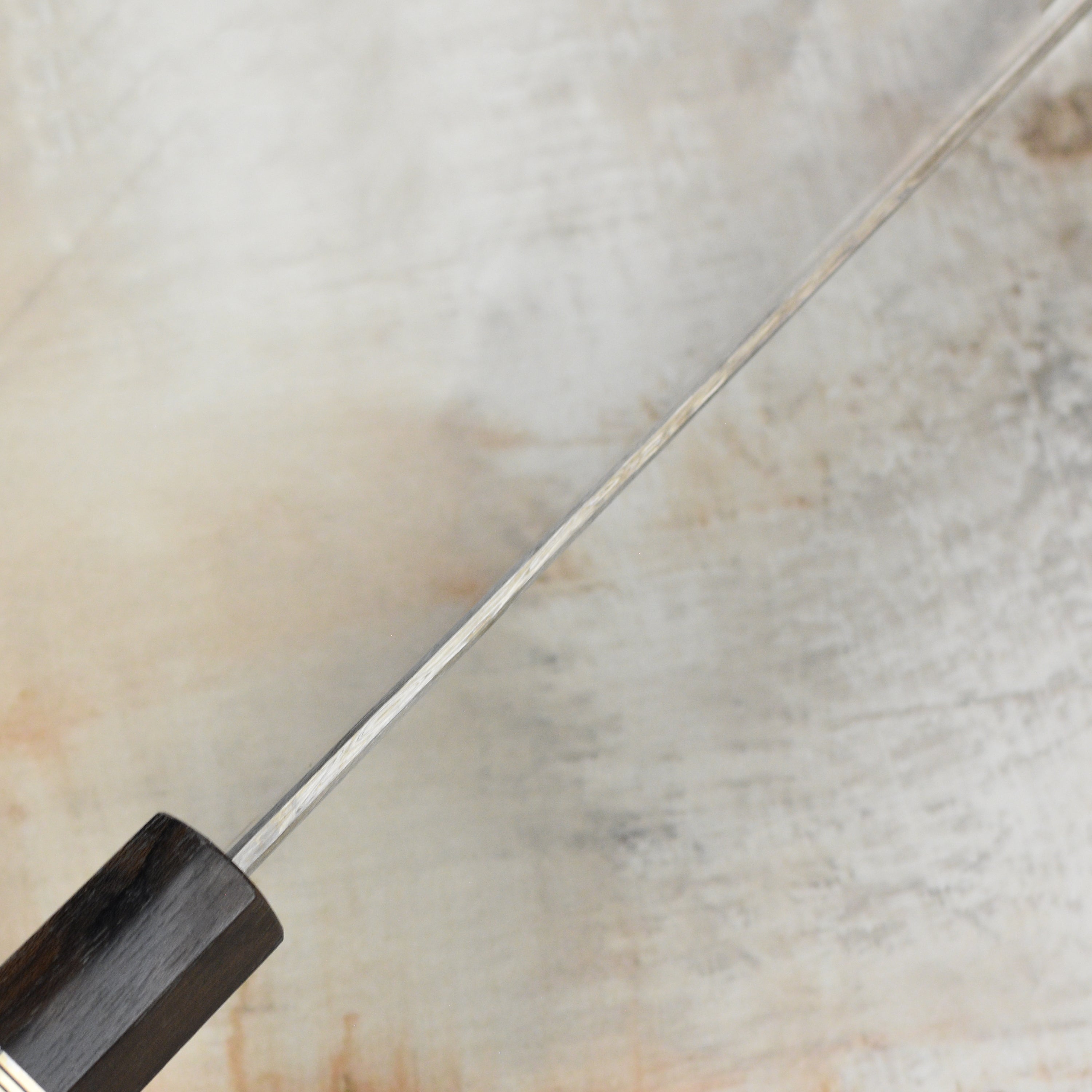 Shiomachi Aogami Gyuto knife displayed on a wooden cutting board, illustrating its elegant design and functionality.