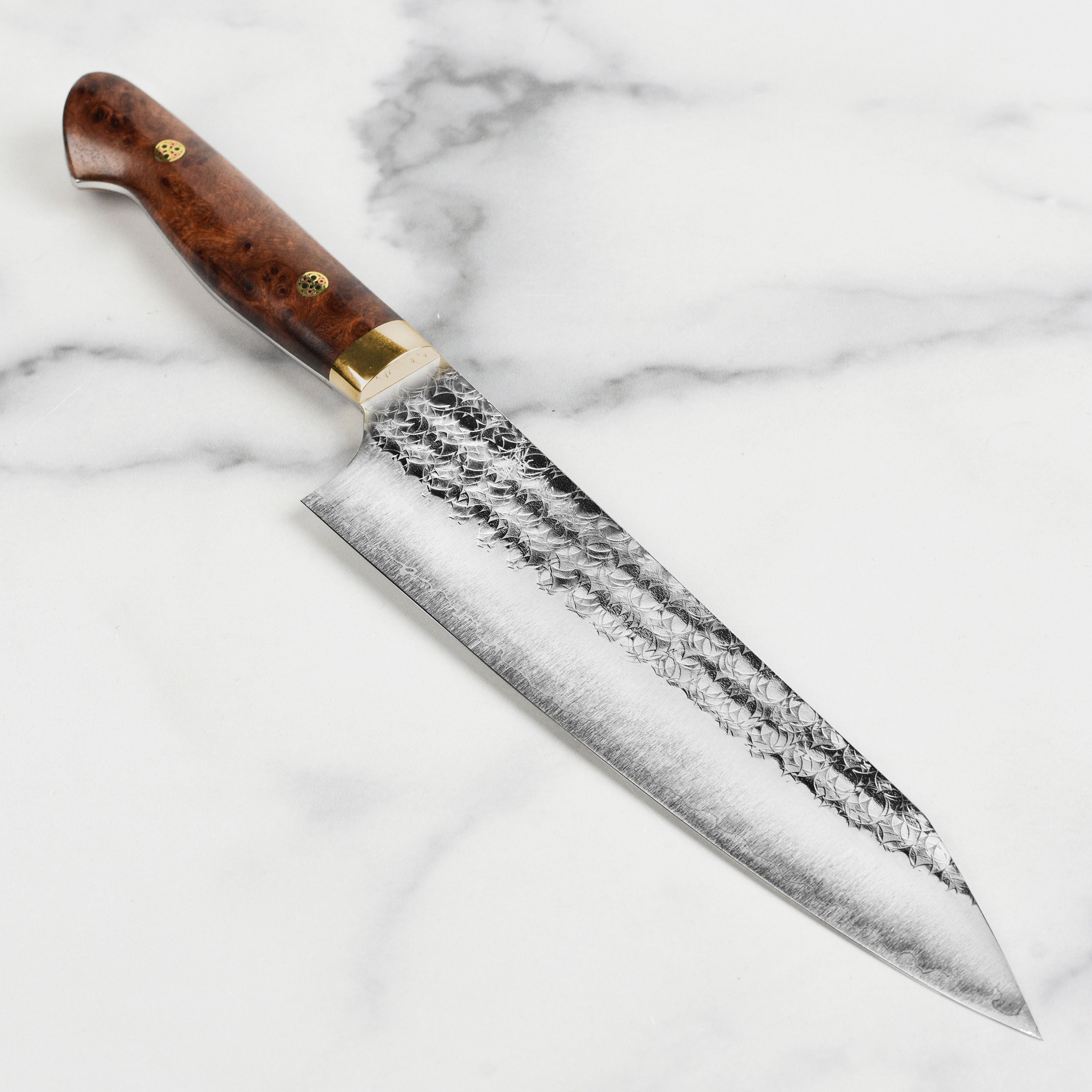 Yoshimi Kato Minamo SG2 Kiritsuke Gyuto Knife from a side angle, highlighting the blade and handle design.