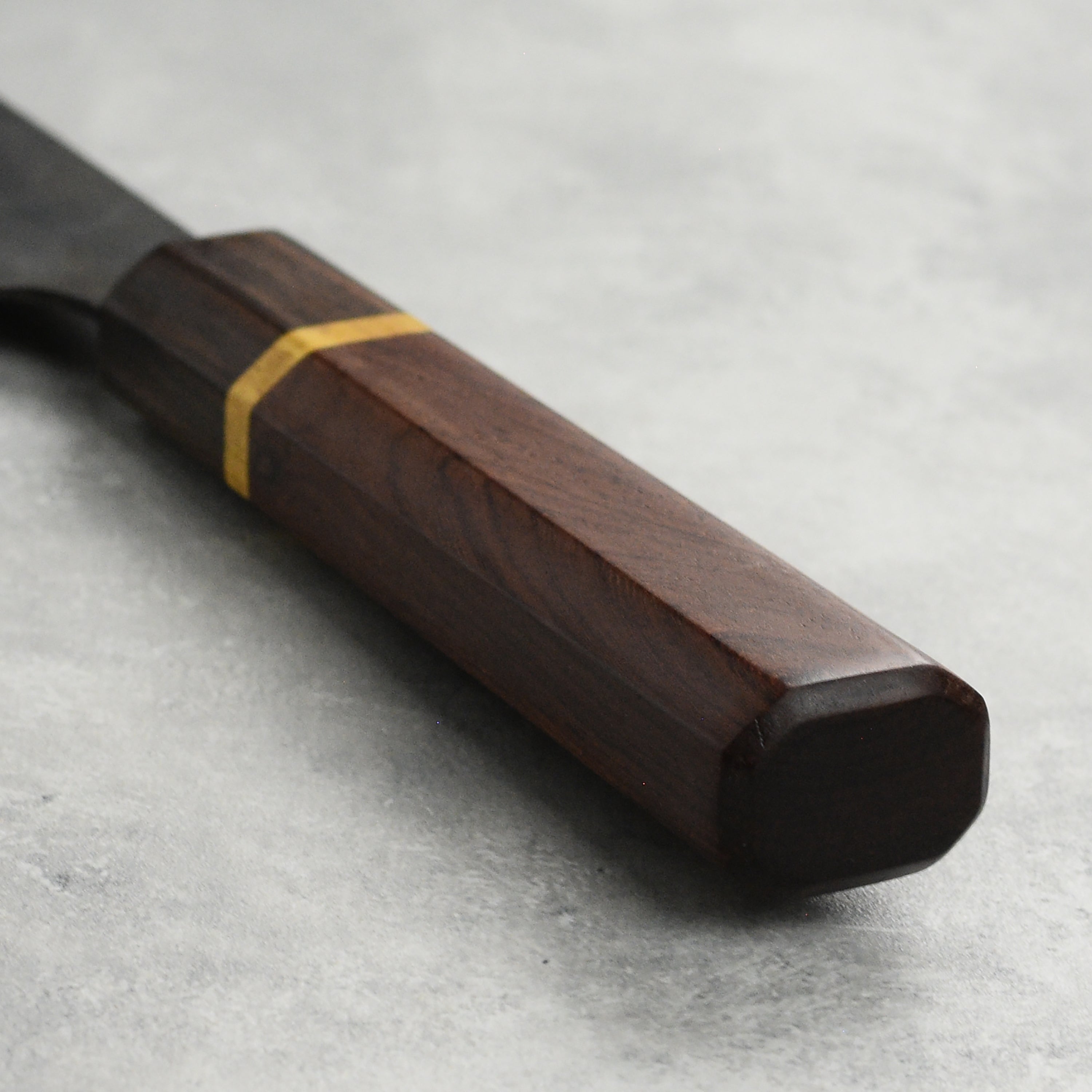 Top view of 6.5-inch carbon steel nakiri knife slicing vegetables in a kitchen setting