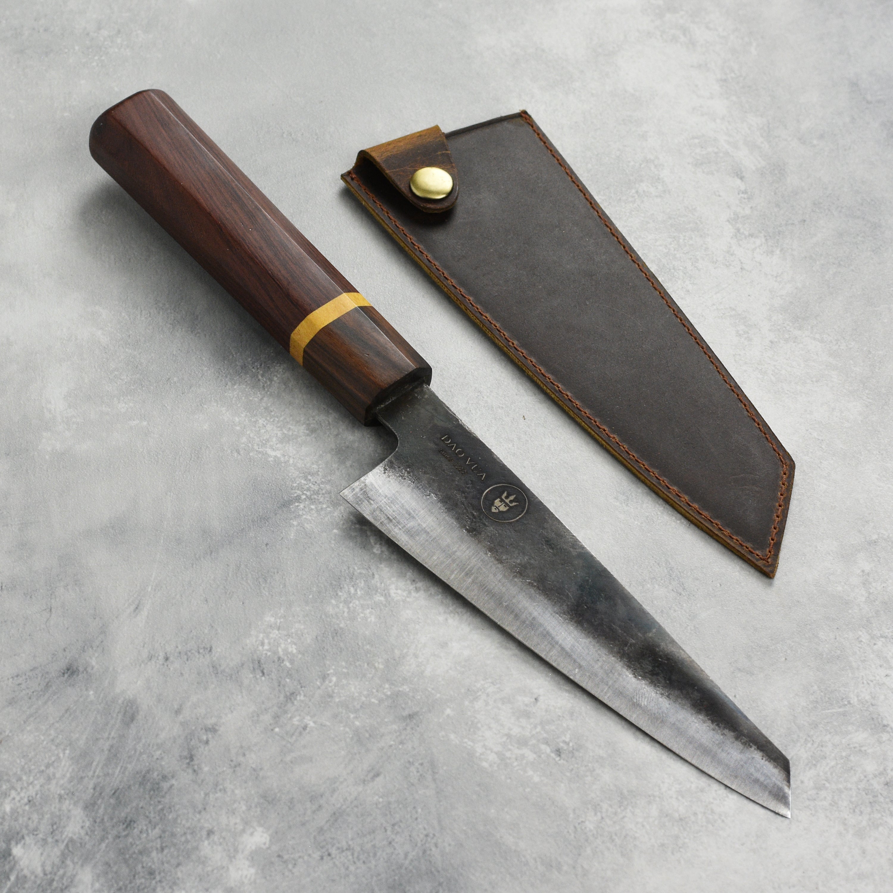 Dao Vua V3 honesuki knife displayed on a wooden cutting board, highlighting its sharp blade and handle.
