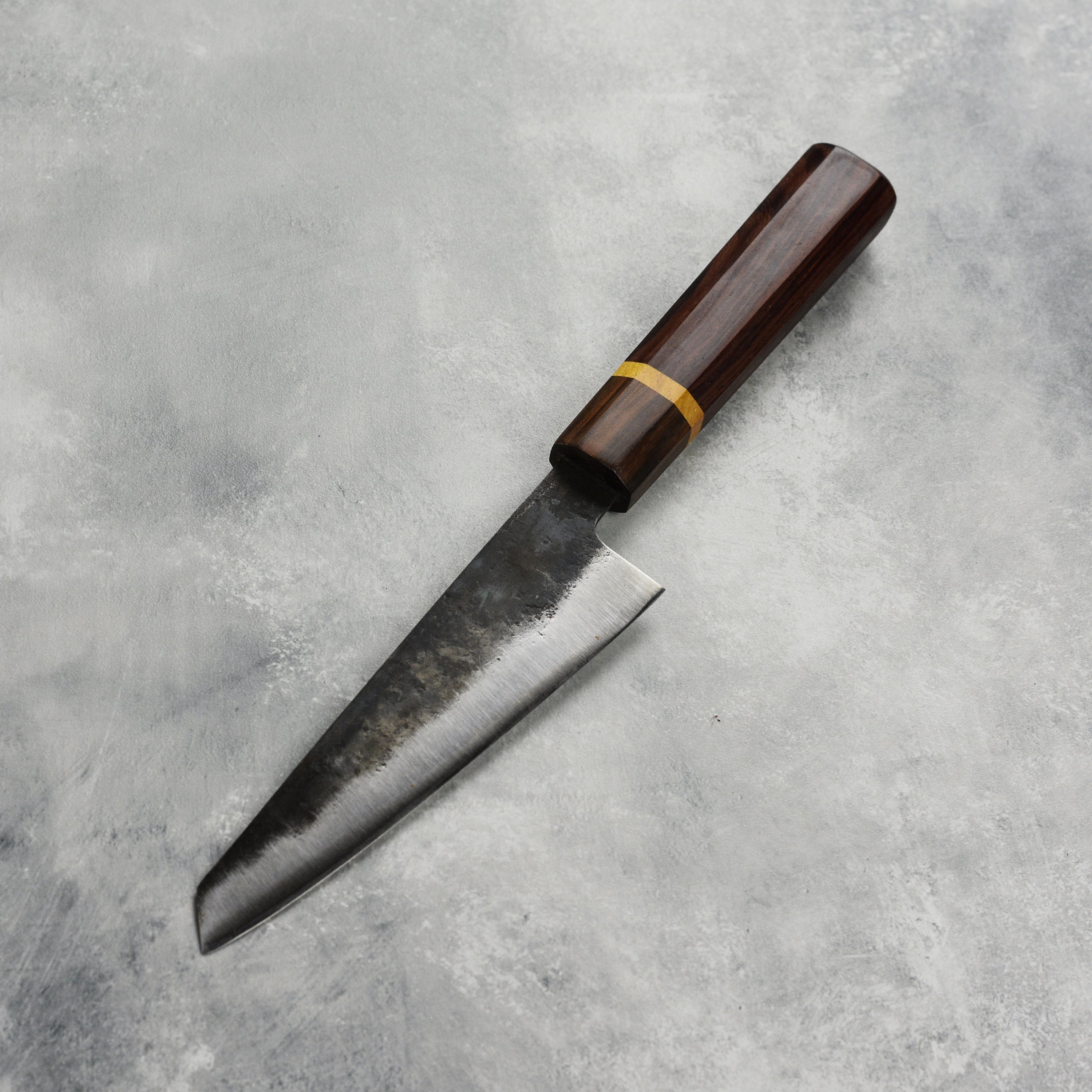 Dao Vua V3 honesuki knife displayed on a wooden cutting board, highlighting its sharp blade and handle.