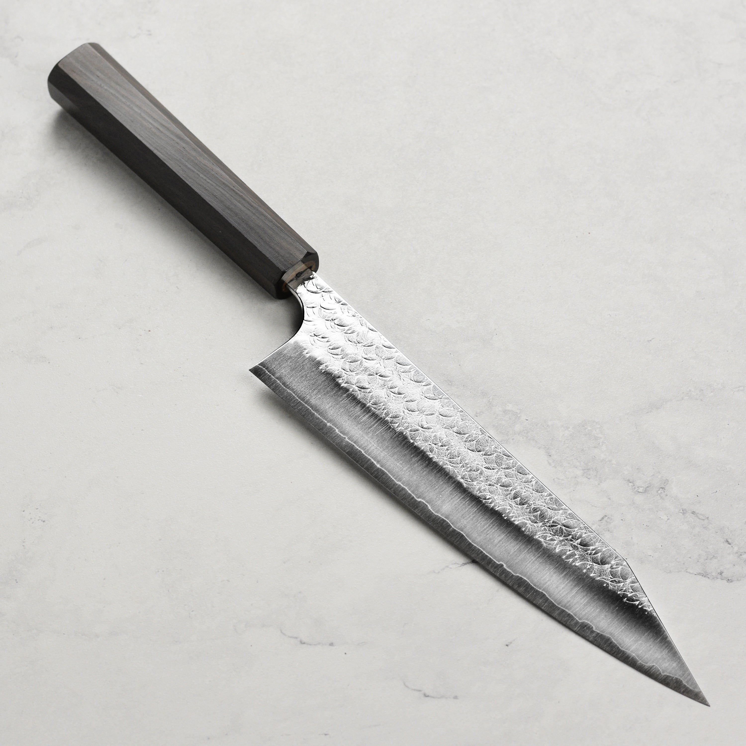Close-up of Minamo SG2 Kiritsuke knife blade, highlighting its sharp edge and craftsmanship.