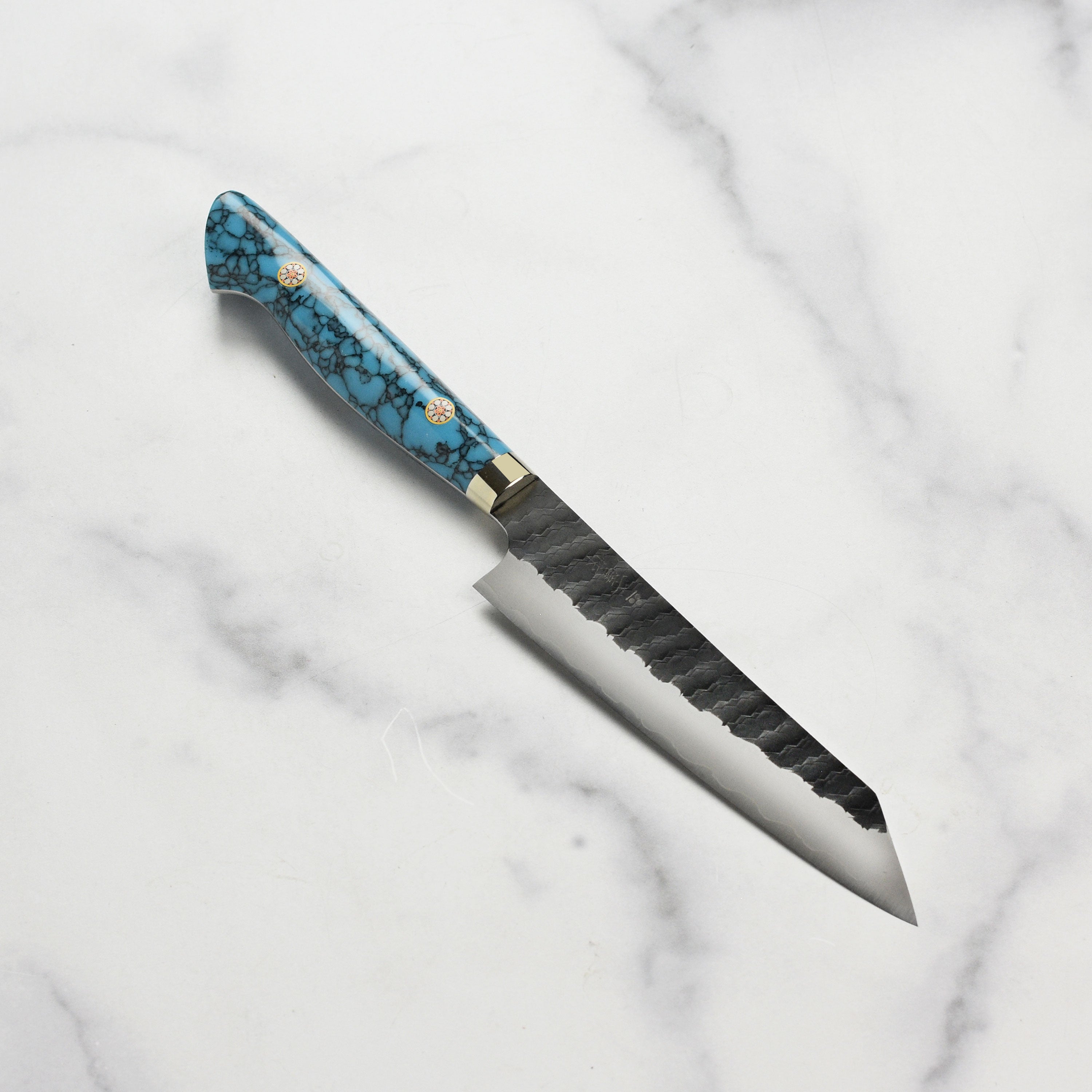 Nigara SG2 Kiritsuke Petty knife on a wooden cutting board, showing its sharp blade and vibrant blue handle