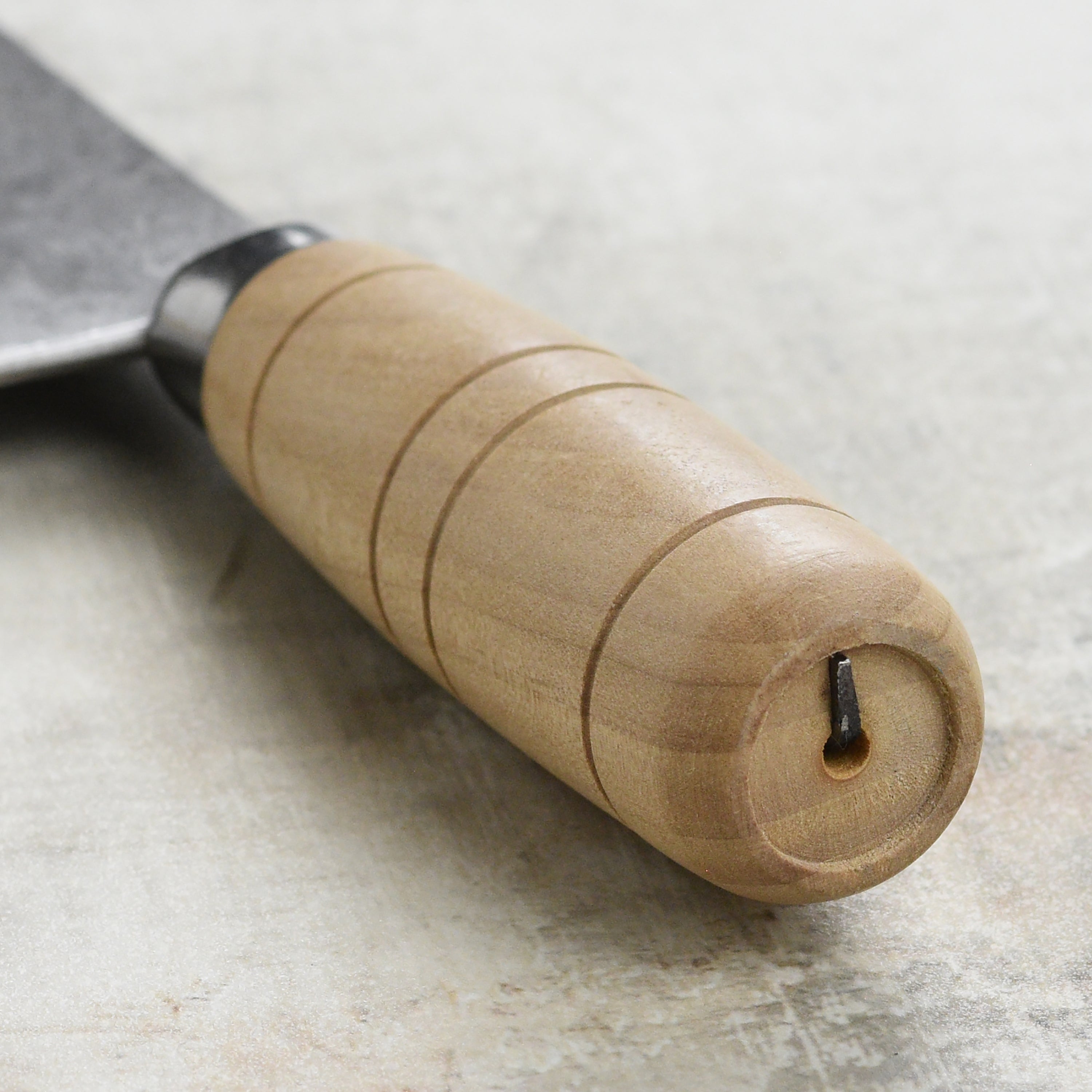 Top-down view of the Rustic Hand-Forged Carbon Steel 8" Chinese Cleaver on a cutting board, perfect for slicing vegetables.