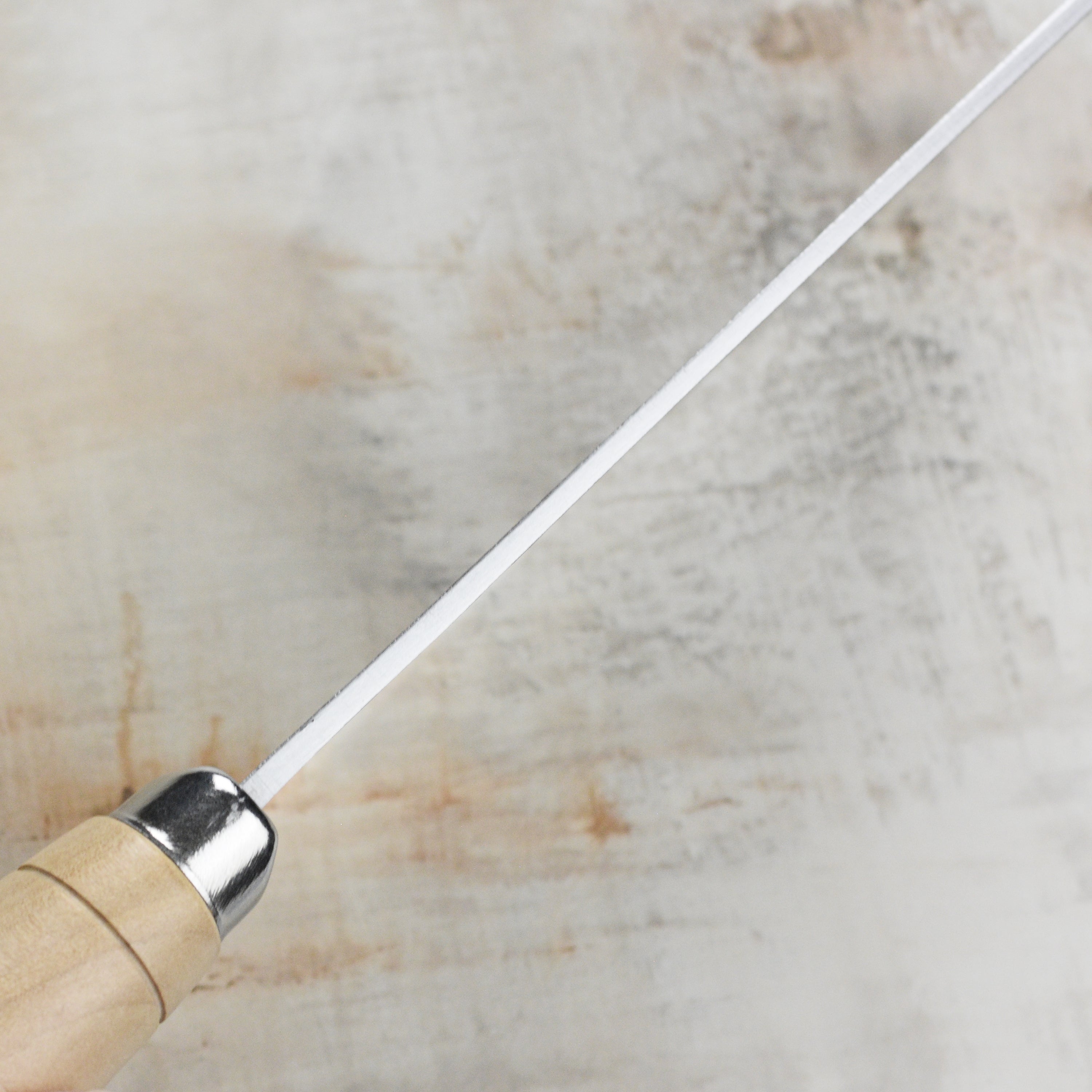Close-up of the barrel-style maple handle and stainless steel ferrule of the Rustic Hand-Forged Carbon Steel 8" Chinese Cleaver.