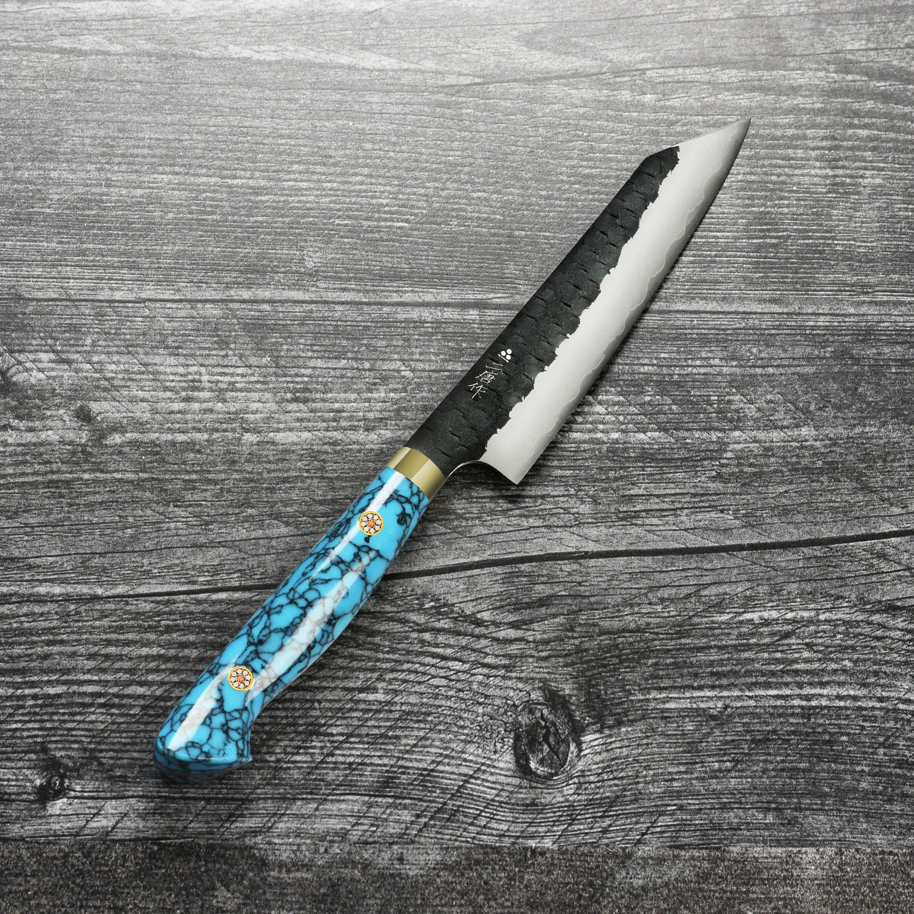 Nigara SG2 Kiritsuke Petty knife on a wooden cutting board, showing its sharp blade and vibrant blue handle