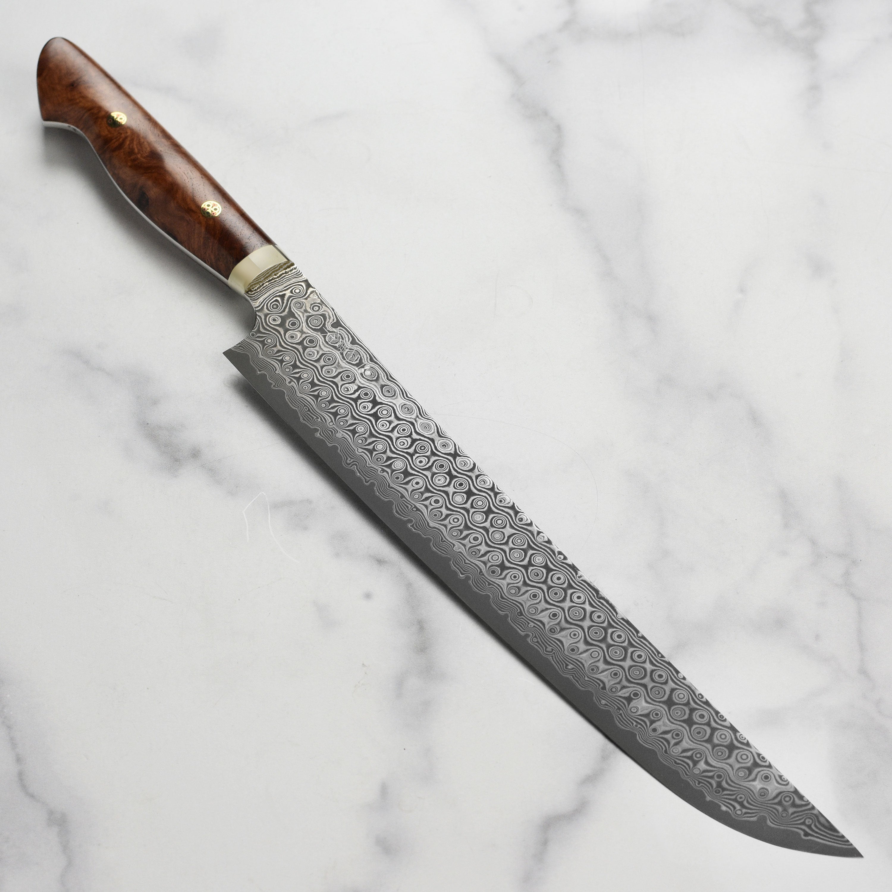 Nigara Damaskus sujihiki knife with quince wood handle on cutting board