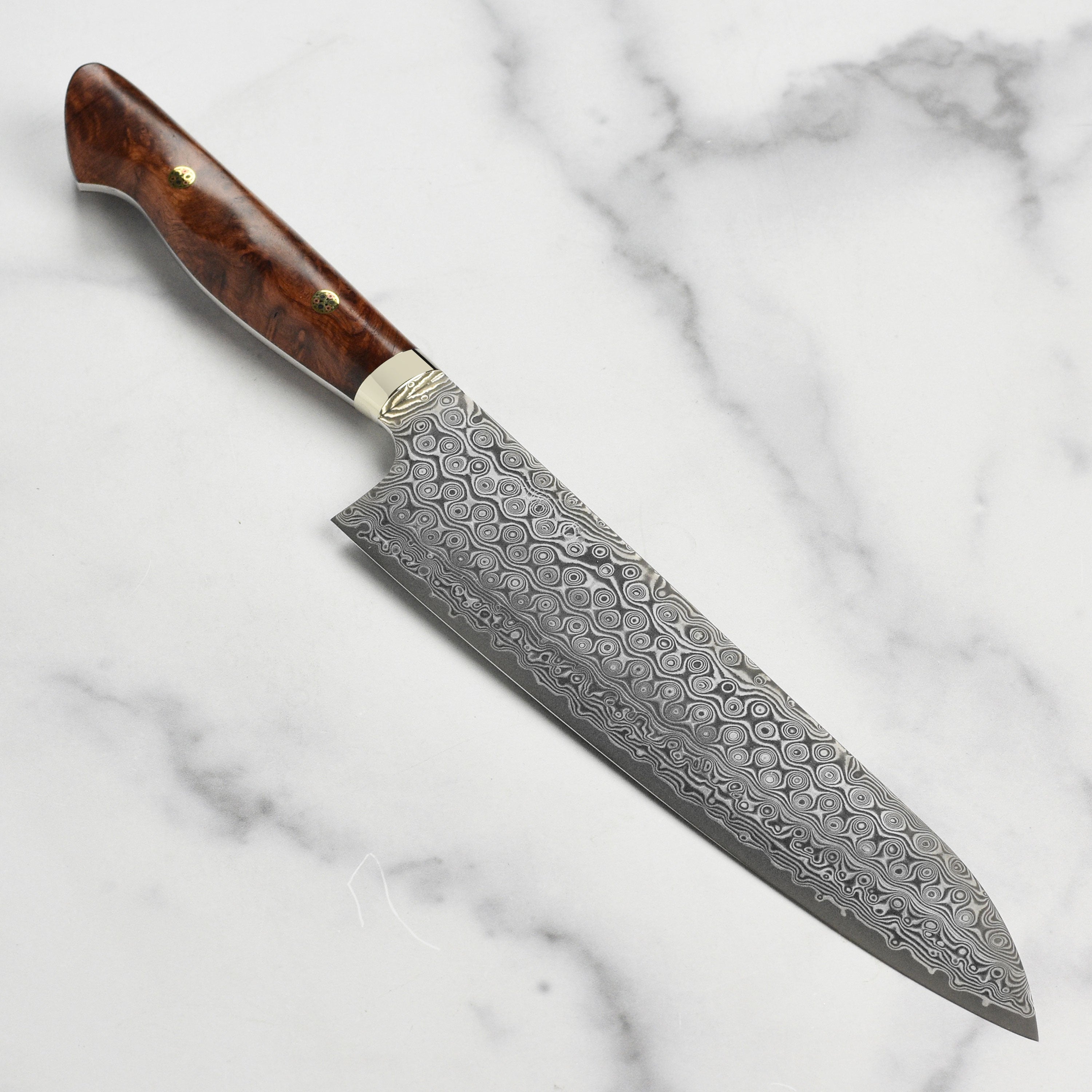 Close-up of Nigara Anmon SG2 Damascus gyuto blade highlighting layered steel pattern