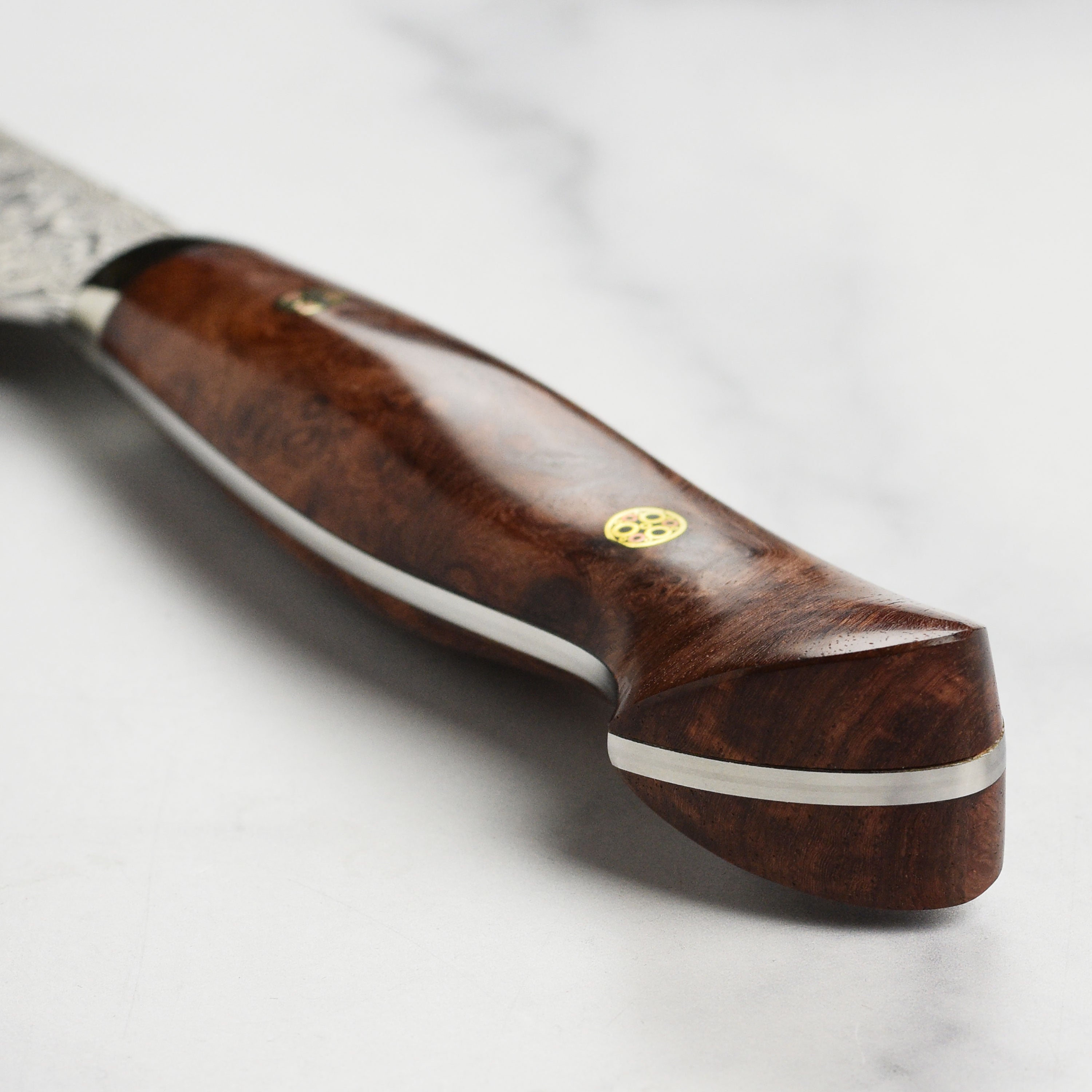 Japanese kitchen knife with quince wood handle resting on cutting board