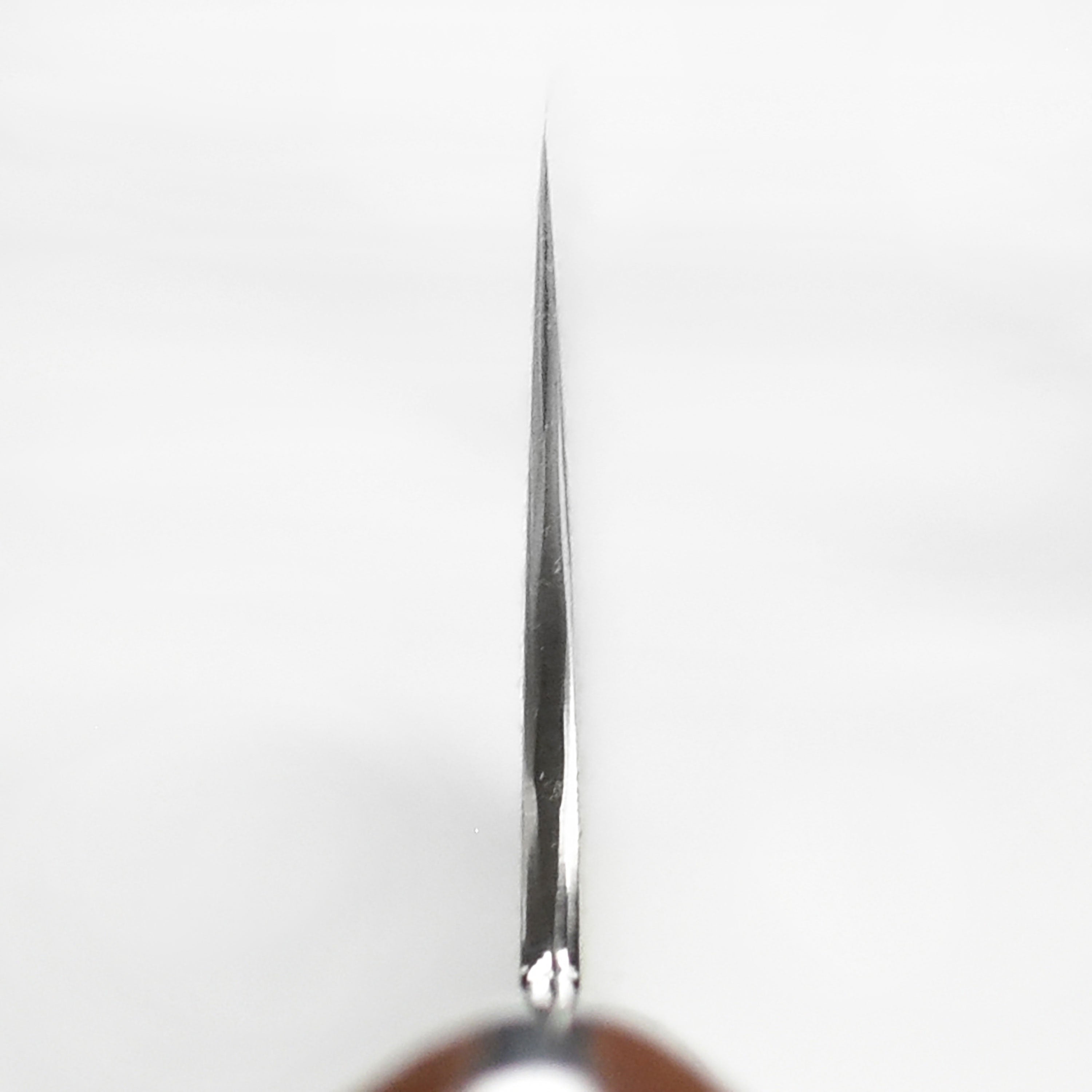 Chef slicing vegetables with Nigara Anmon Damascus gyuto in professional kitchen