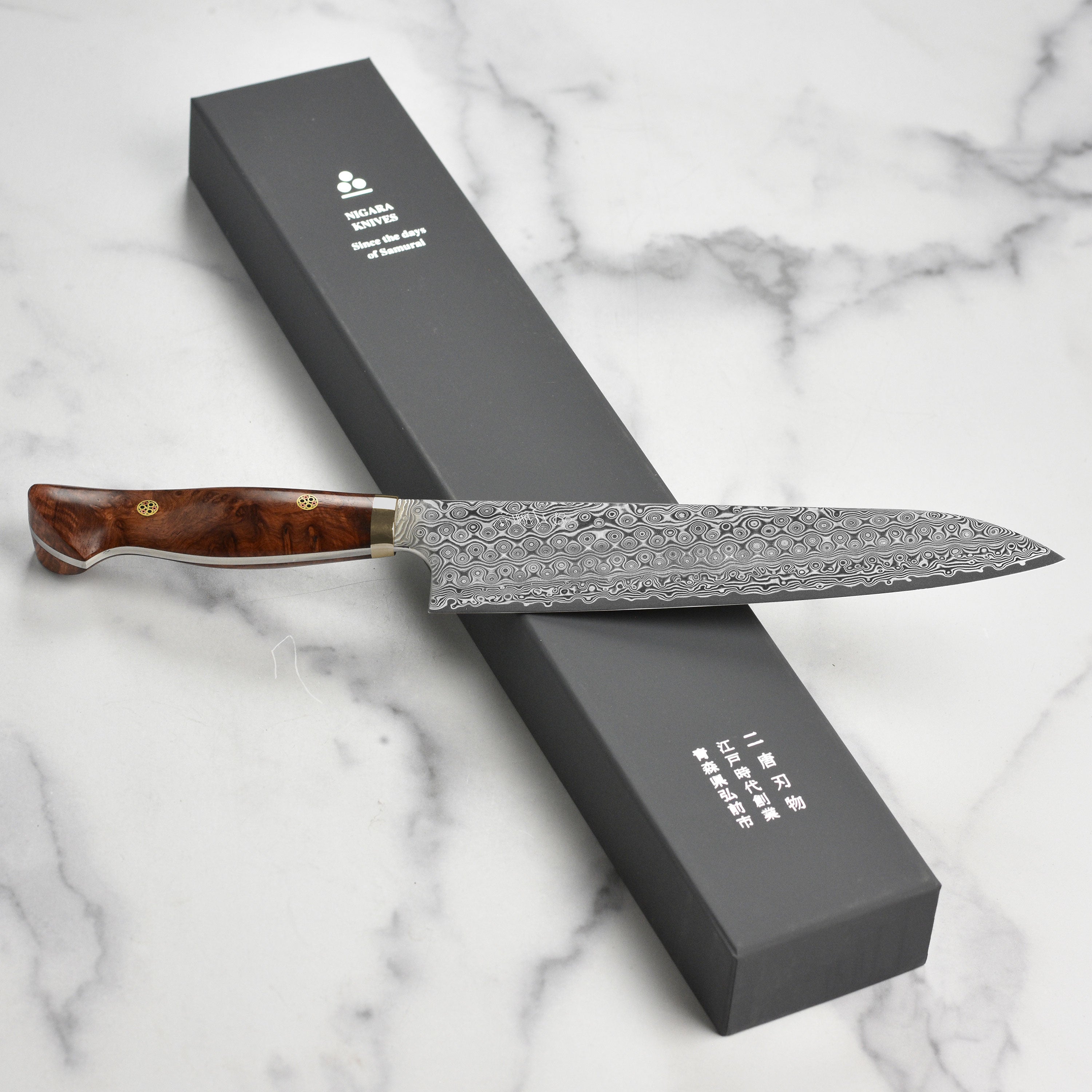 Close-up of Nigara Anmon SG2 Damascus gyuto blade highlighting layered steel pattern