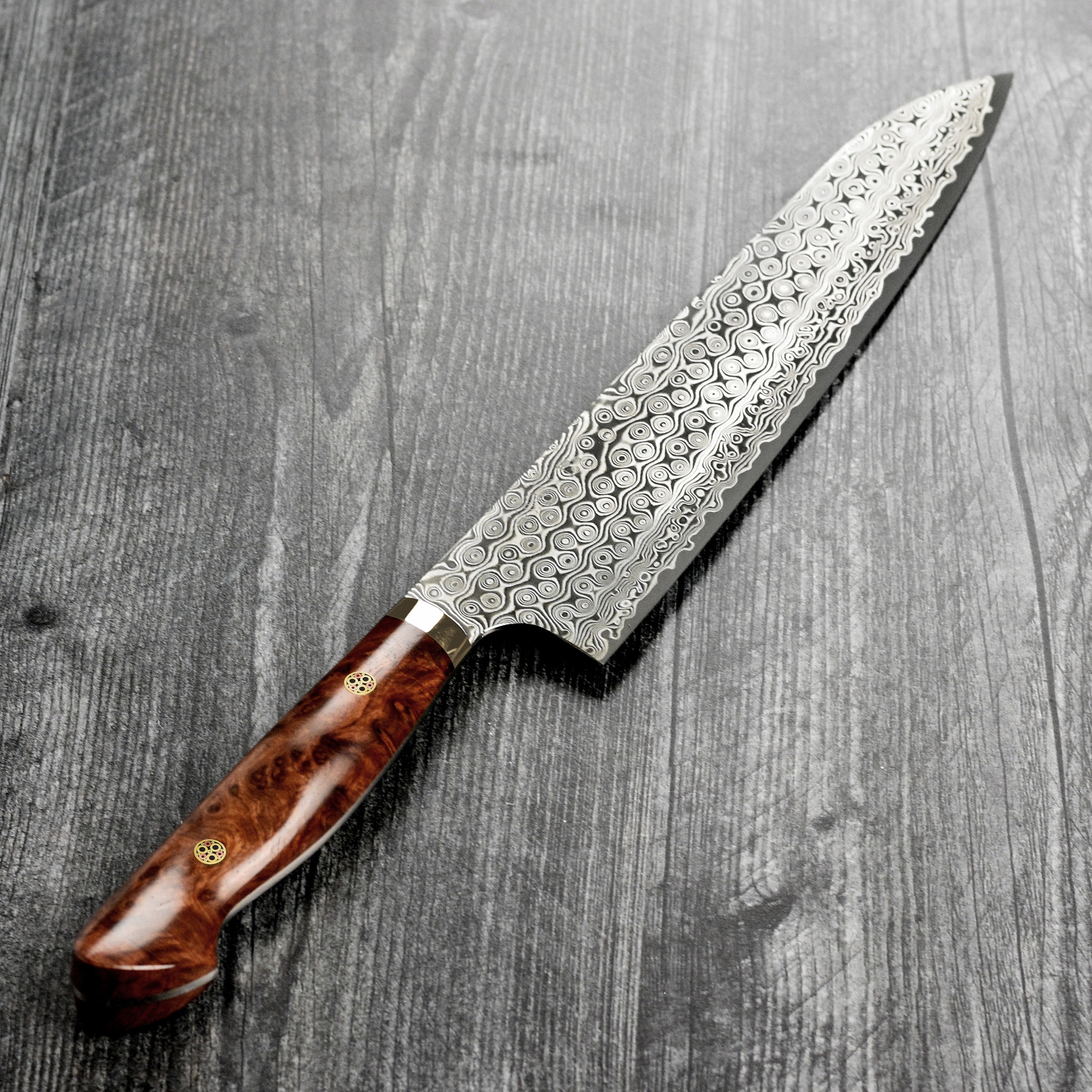 Japanese kitchen knife with quince wood handle resting on cutting board