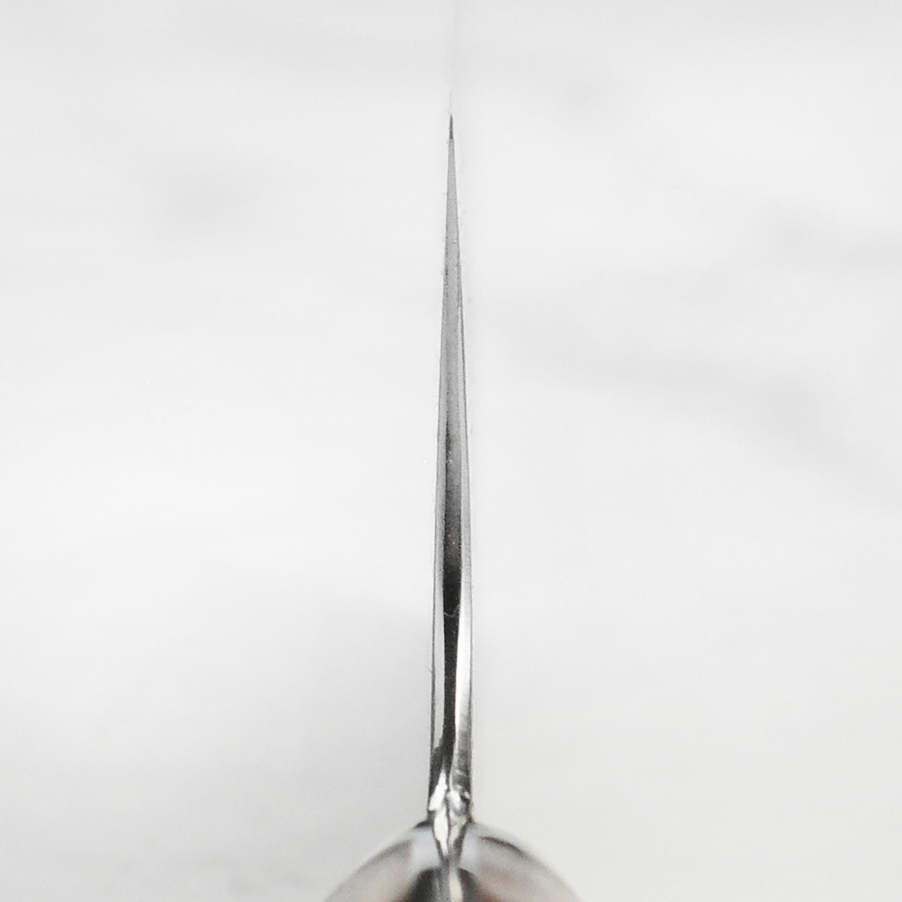 Close-up of the blade of the Nigara Anmon SG2 Damascus Nakiri knife showcasing its sharpness and craftsmanship.
