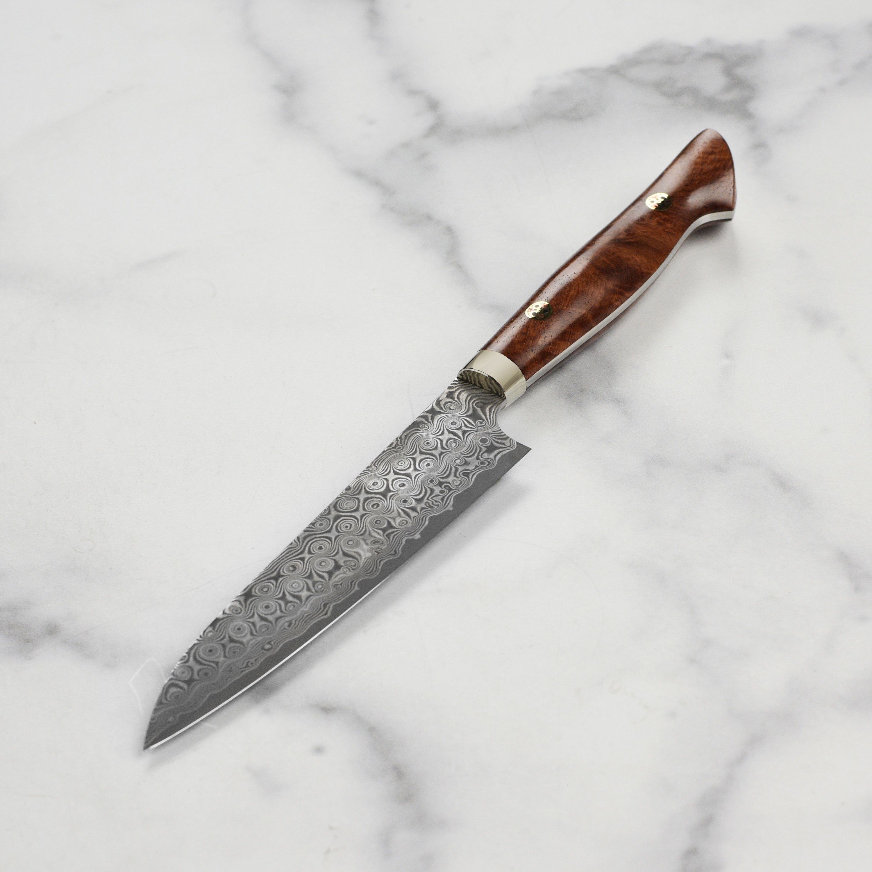 Japanese knives displayed together, highlighting the Nigara Anmon SG2 petty knifes craftsmanship