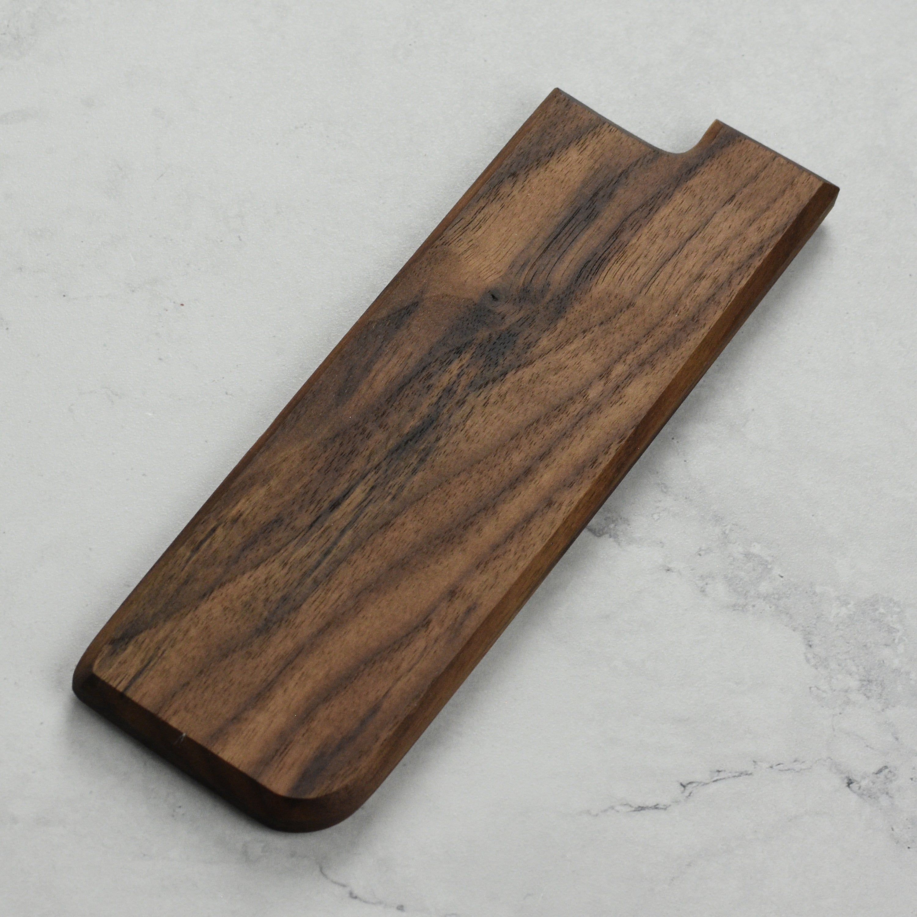 Elegant walnut magnetic saya displayed on a kitchen countertop.