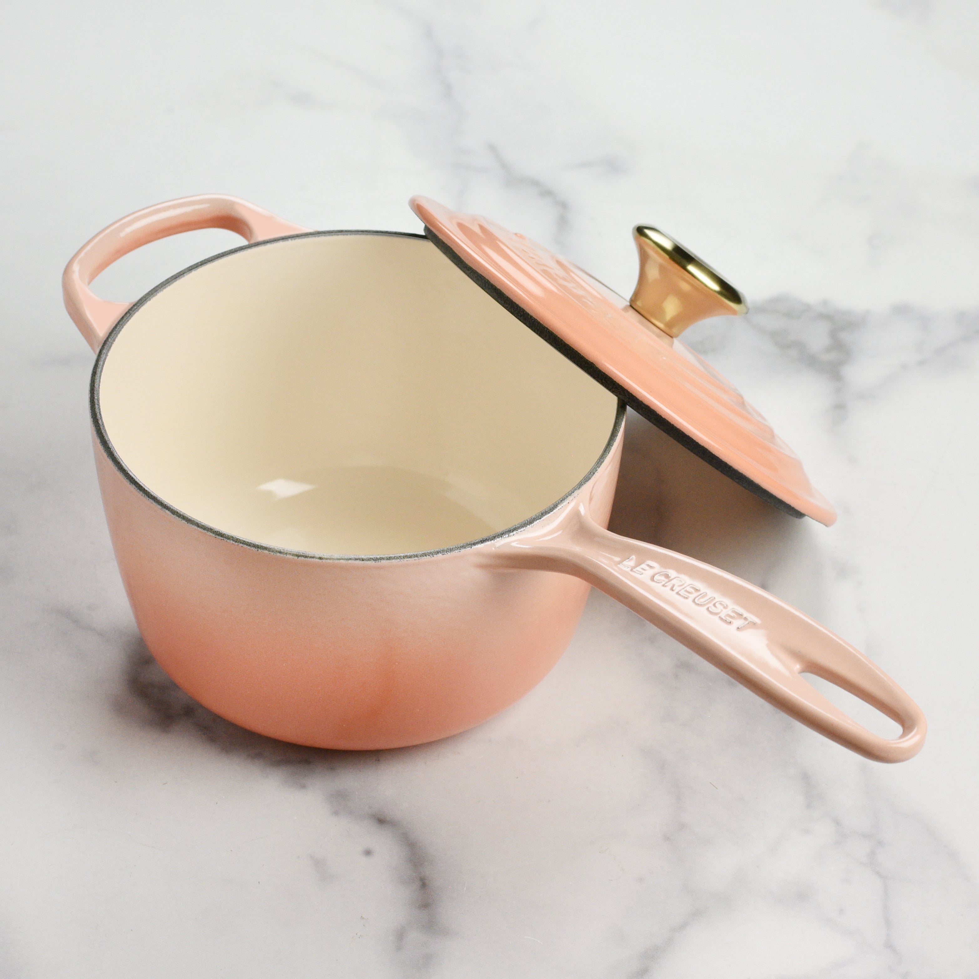 Close-up of Le Creuset enameled cast iron saucepan with lid, showcasing its durable finish.