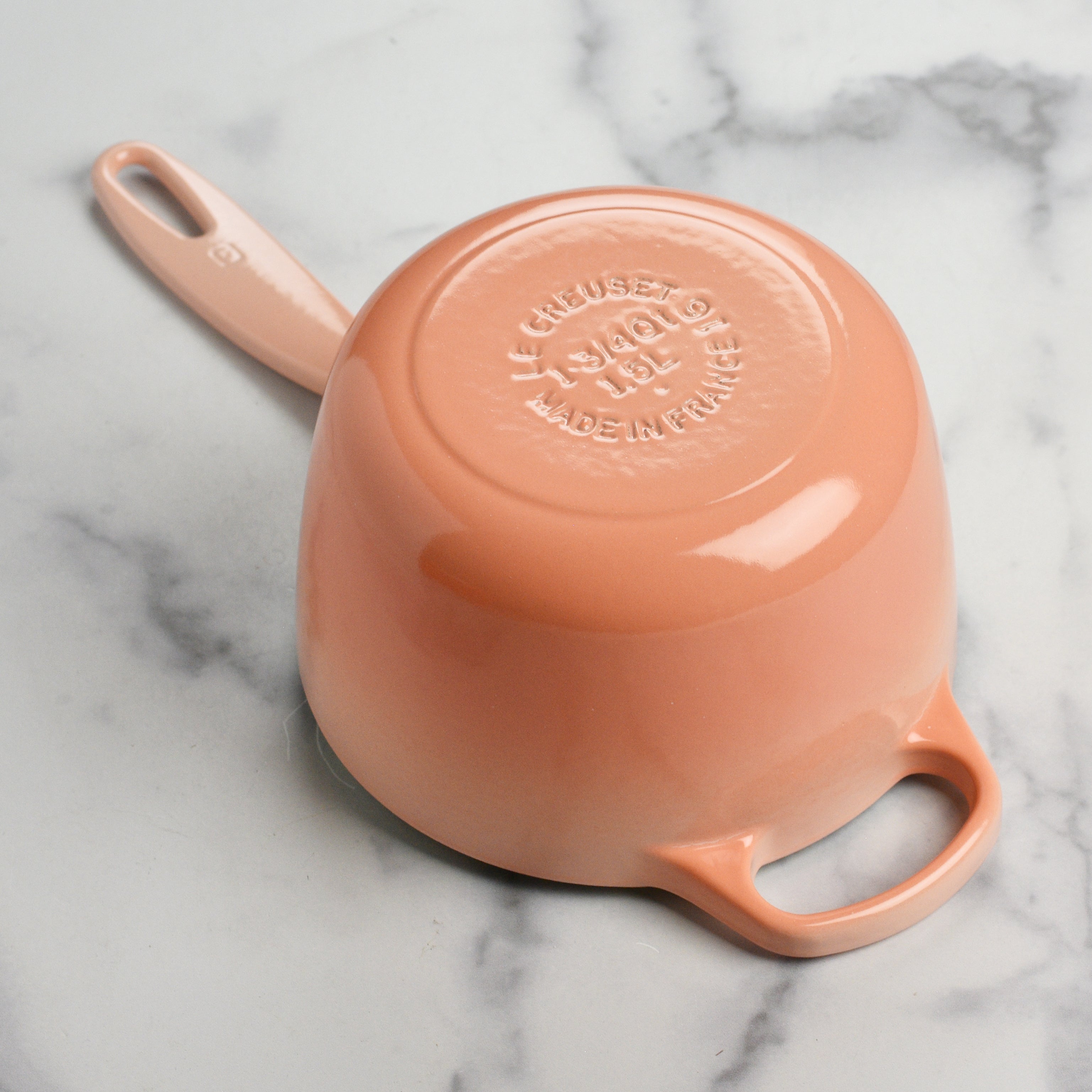 Side view of Le Creuset 1.75 qt saucepan with ergonomic handle and tight-fitting lid.