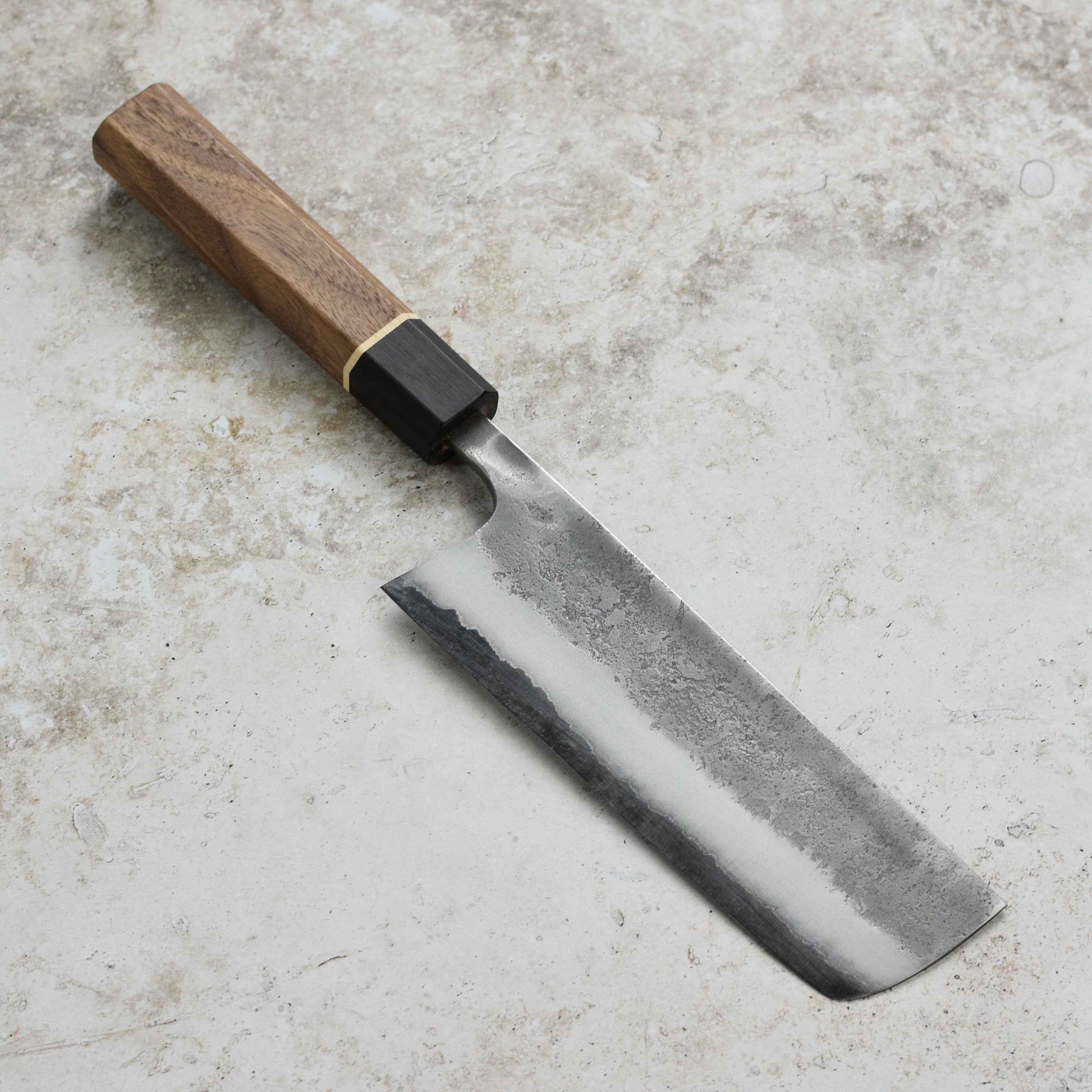 Matsubara Nakiri knife on a wooden cutting board, highlighting its stainless steel finish.