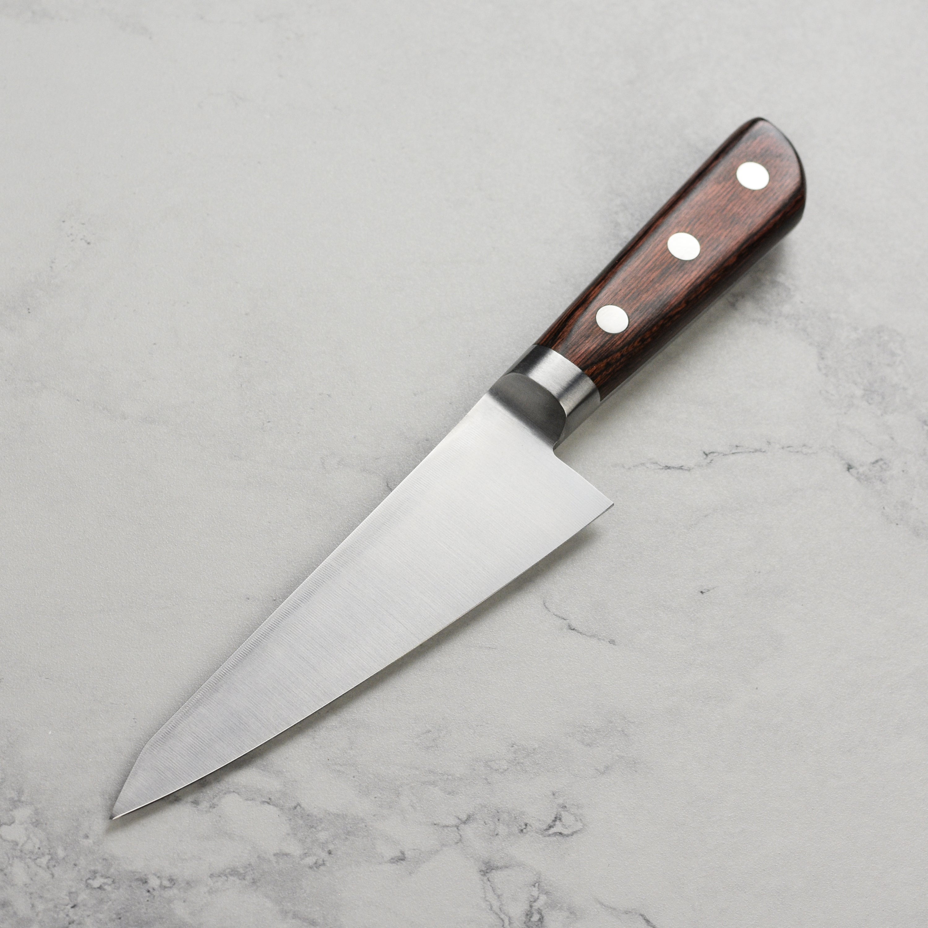 Close-up of the Takayuki Aogami Honesuki knife demonstrating its precision cutting edge.
