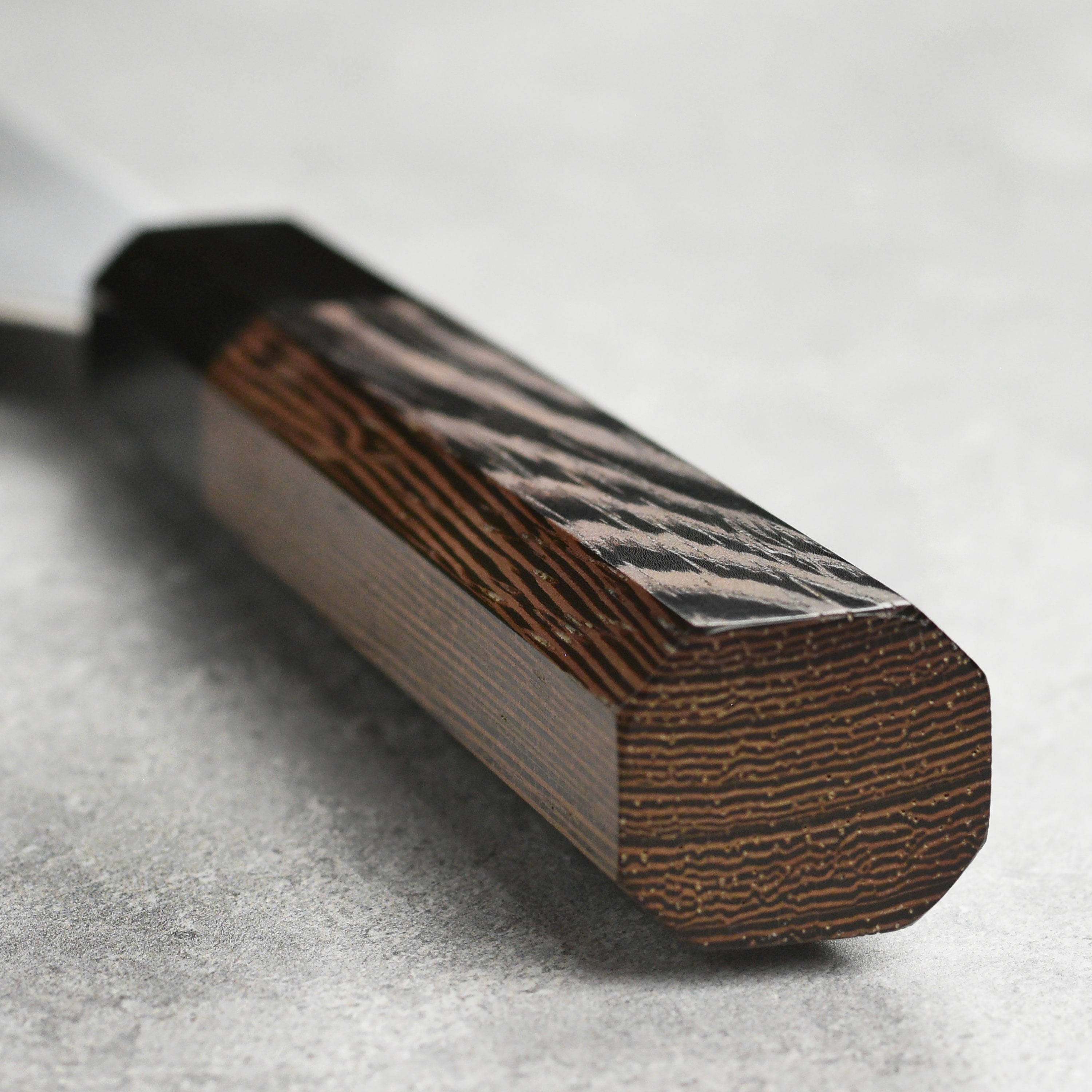 Hatsukokoro Hayabusa Aogami Super Bunka Knife in action, slicing vegetables on a wooden cutting board.