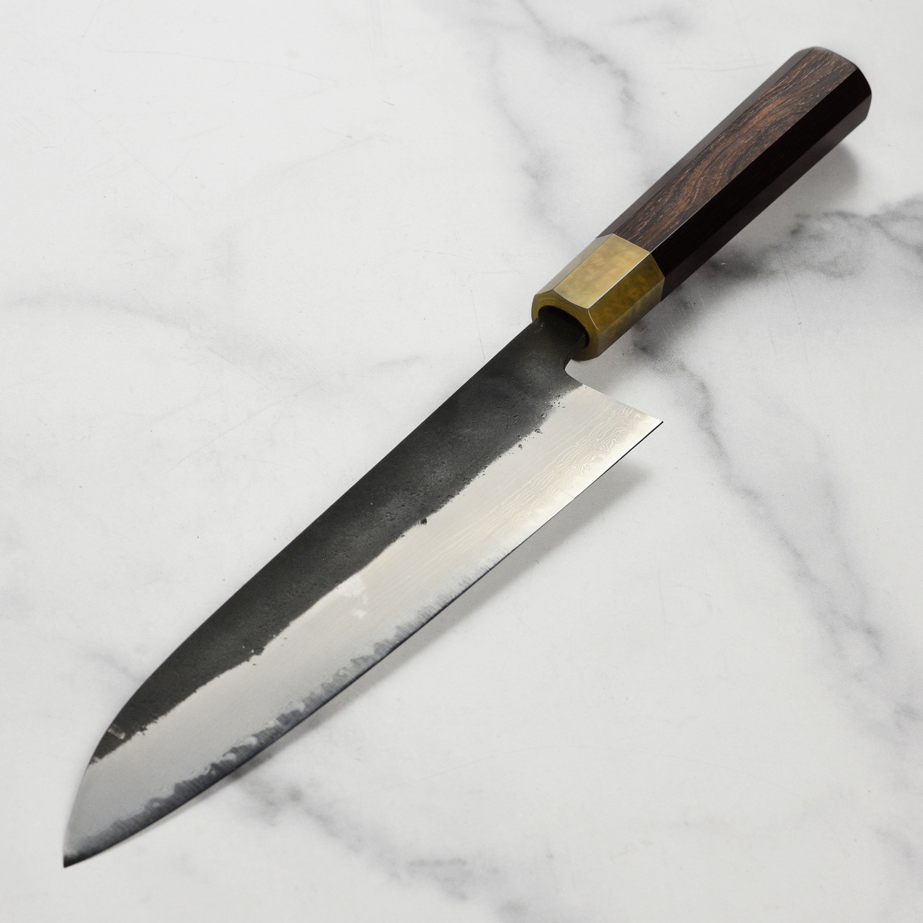 Side view of the Hatsukokoro Gyuto Knife displaying its ebony handle and craftsmanship.