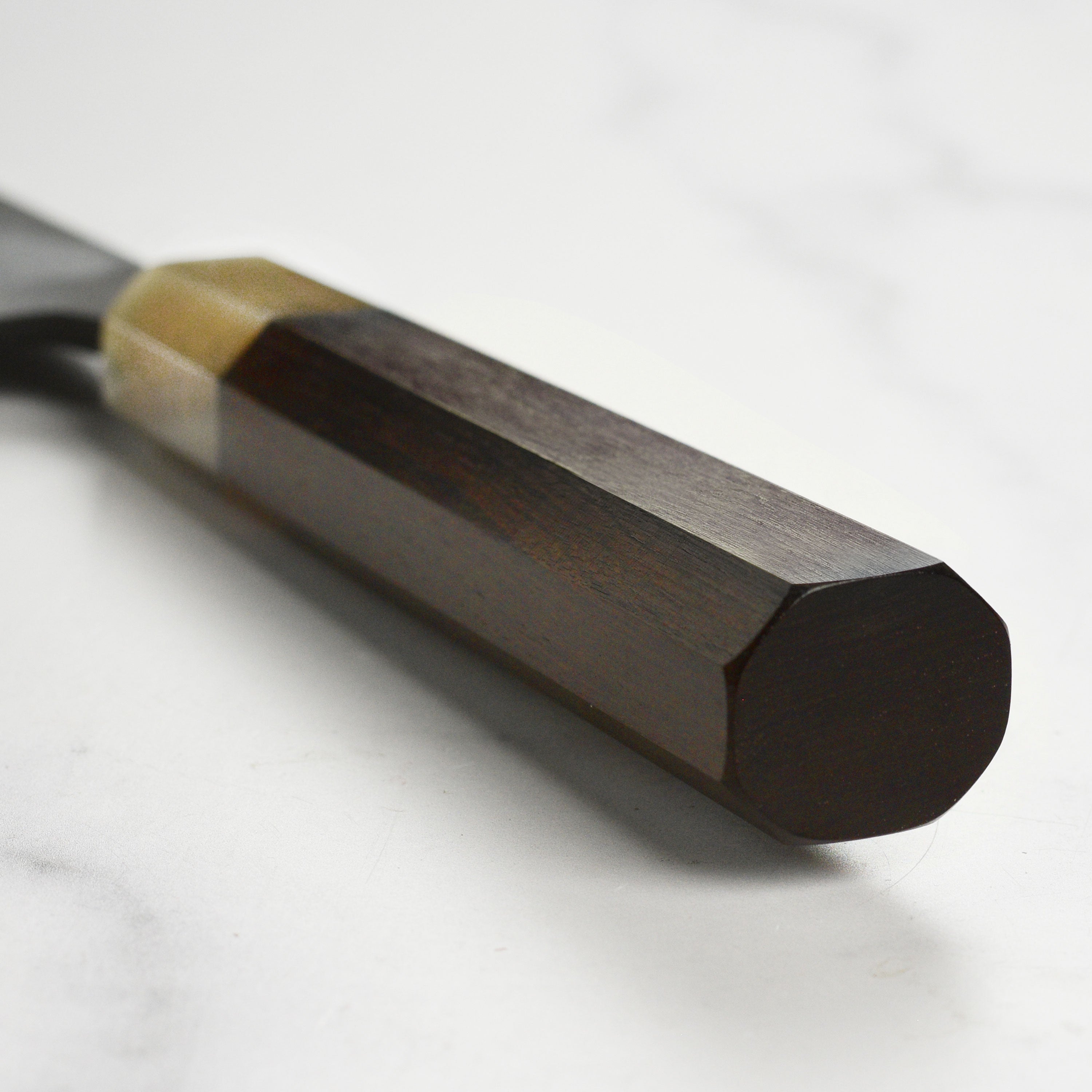 Hatsukokoro Gyuto Knife in use, expertly cutting fresh vegetables on a wooden board.