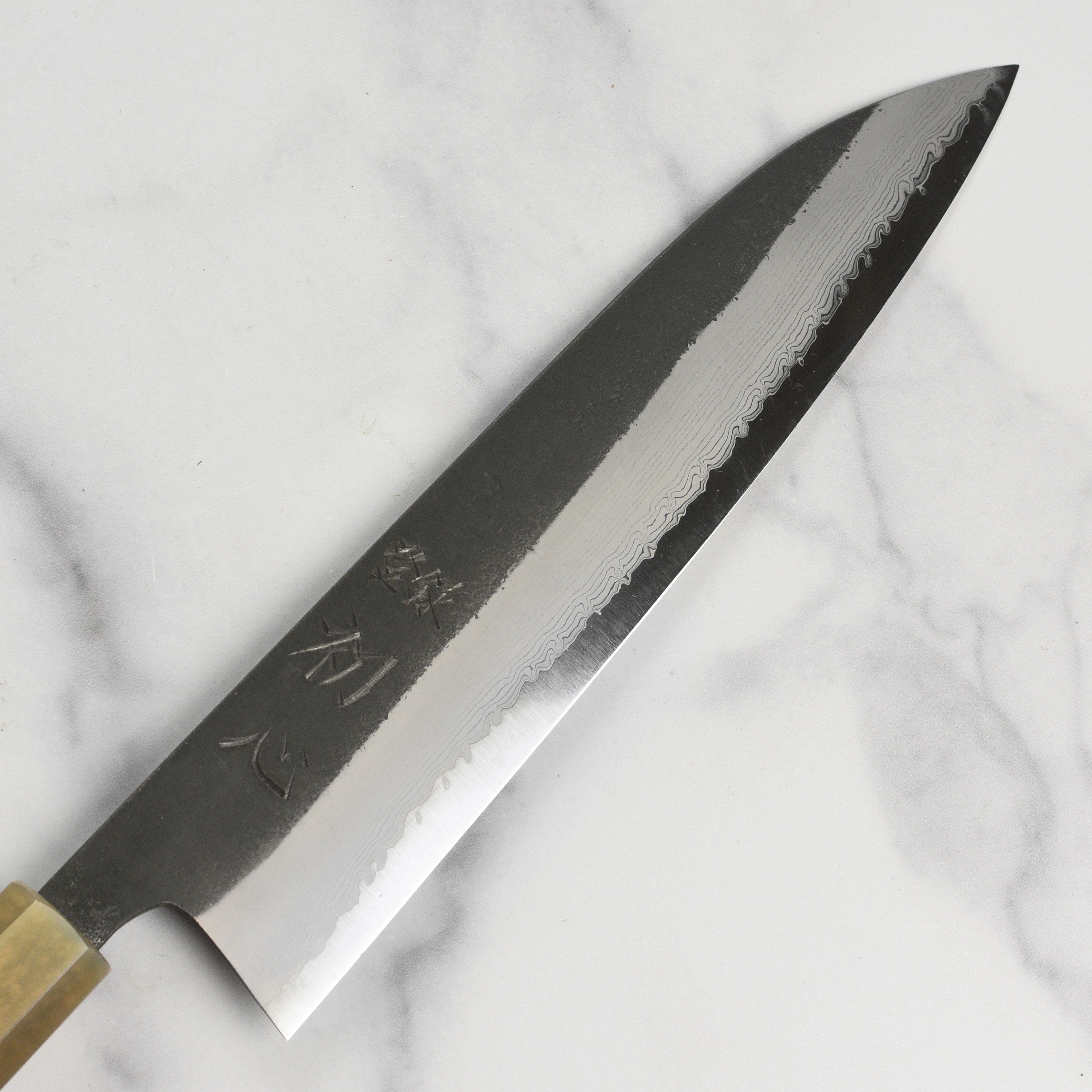 Side view of the Hatsukokoro Gyuto Knife displaying its ebony handle and craftsmanship.