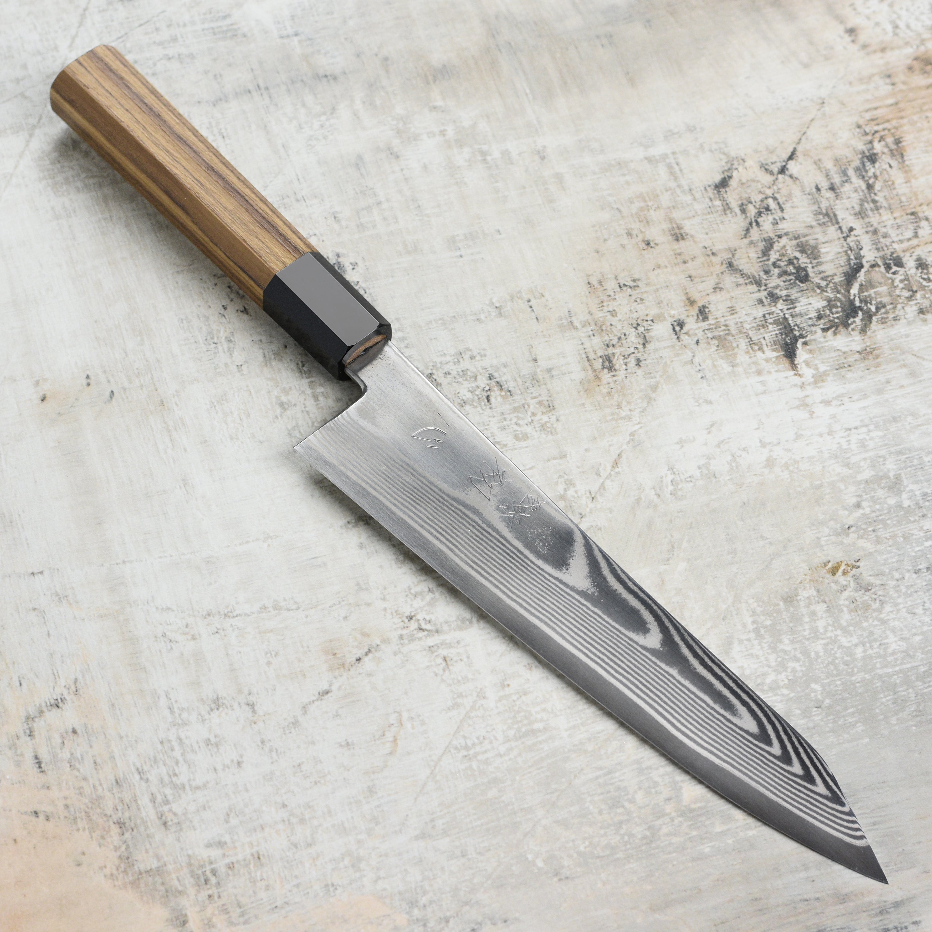 Close-up of Hatsukokoro Ginsou Damascus Gyuto Chef Knife showcasing its sharp blade and ergonomic handle.